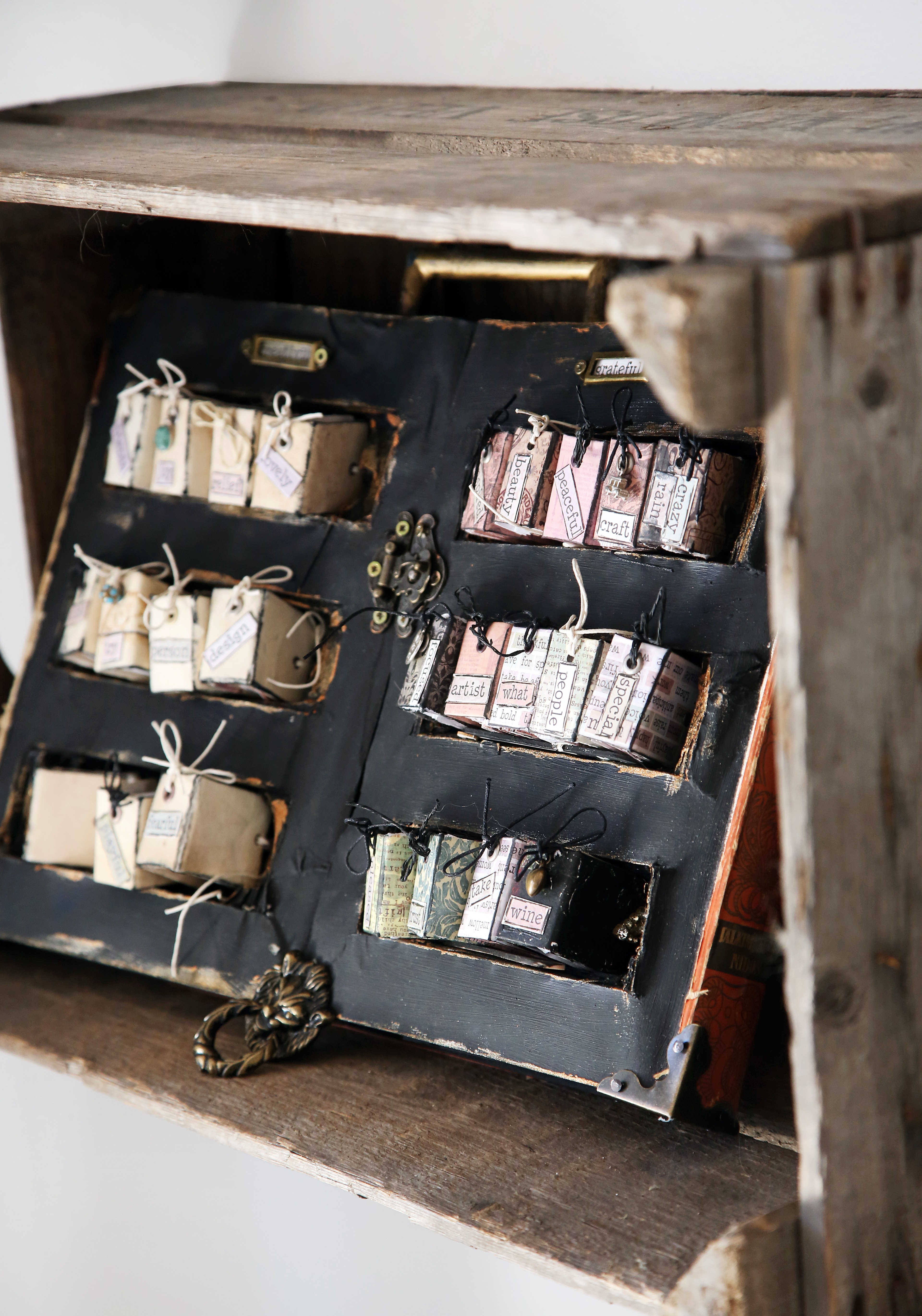 Lena taitaa kirjansidontaa. 32-sivuisilla miniatyyrikirjoilla on jokaisella oma teemansa. Hyllykin on vanha kirja, johon on kaiverrettu sopivat kolot. 