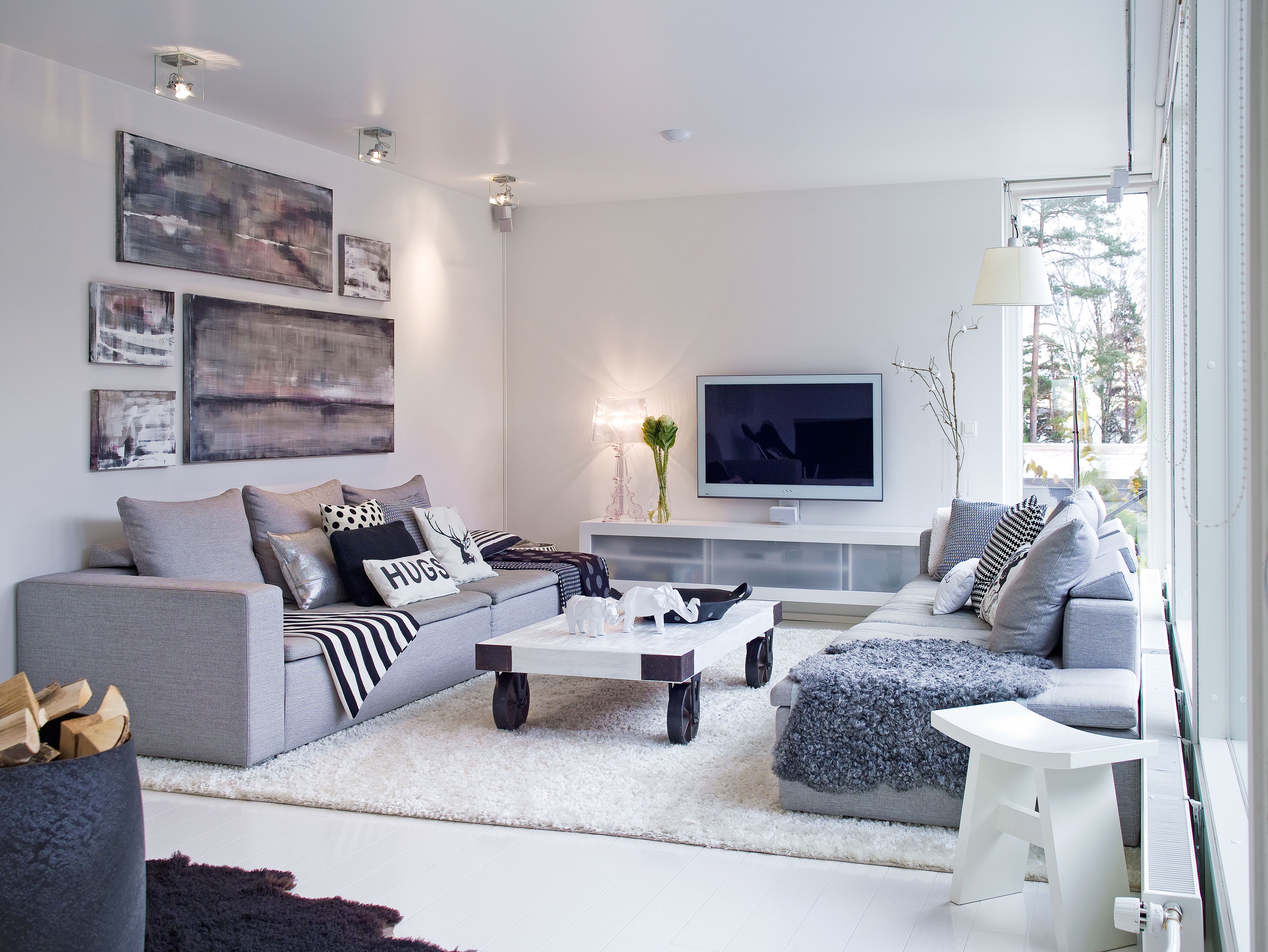 Yläkerran olohuoneen vastakkain asetetut sohvat ovat perheen yhteinen mielipaikka. Massiivinen pöytä tuo sopivasti rosoa sisustukseen. Sen pinta ei helposti kärsi vauhdikkaassakaan leikissä