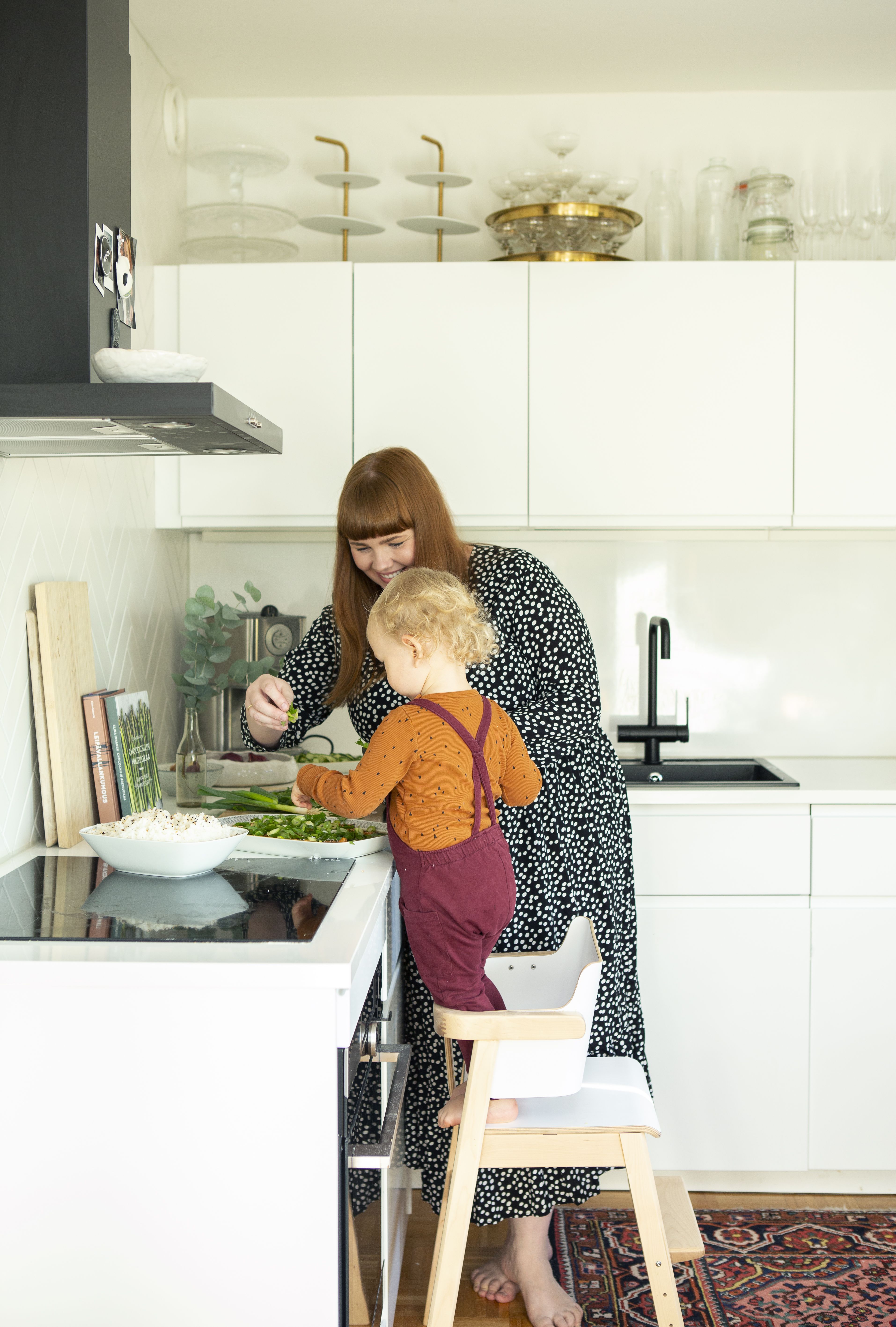Filip, 2, auttaa Heidi-äitiä seesamilohen koristelussa.