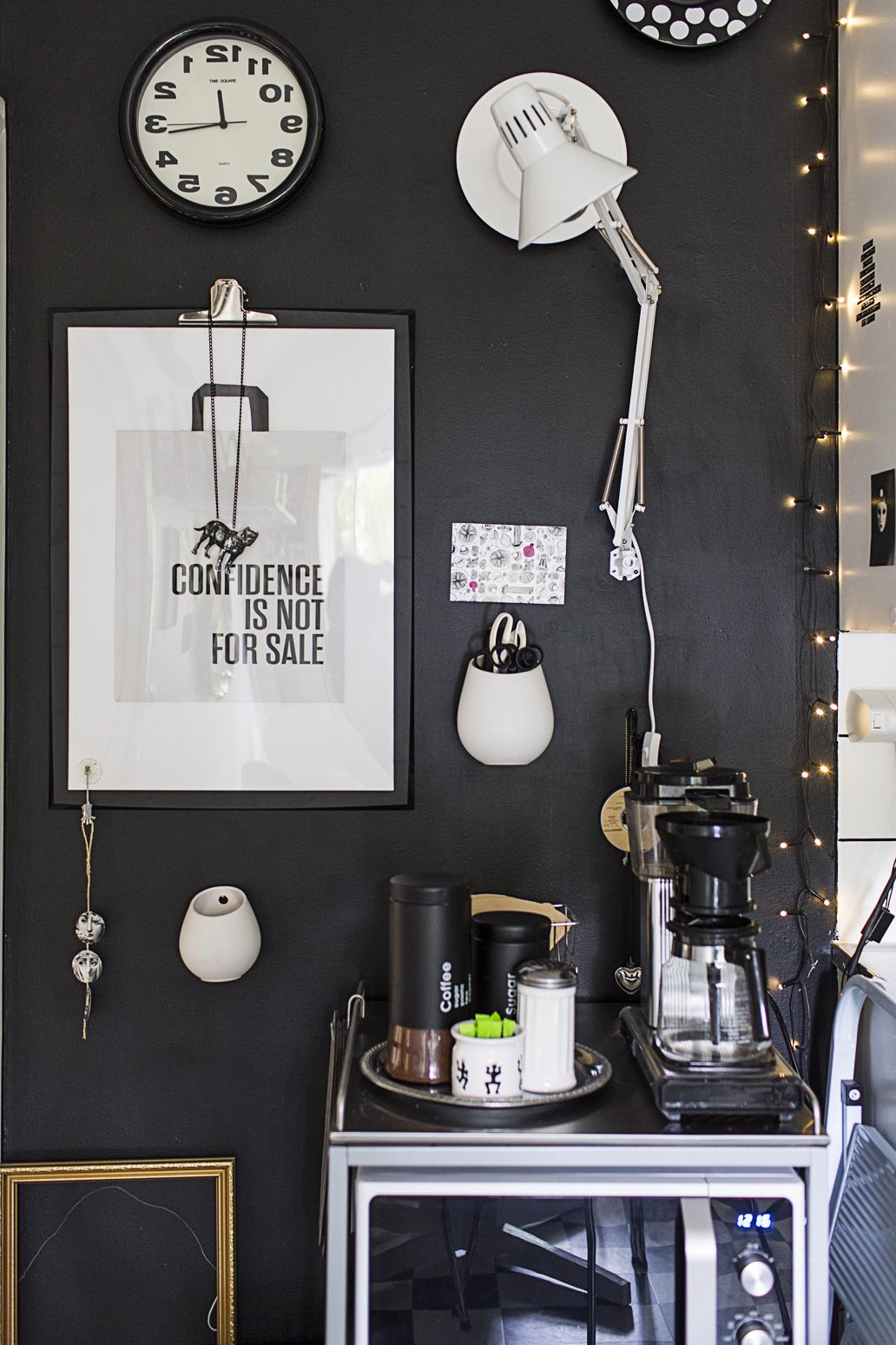 Keittiön seinän Kirsi maalasi mustaksi. Hauska sisustus lähtee metkoista ideoista: paperipussi on päätynyt kehyksiin ja pöytävalaisin seinälle.