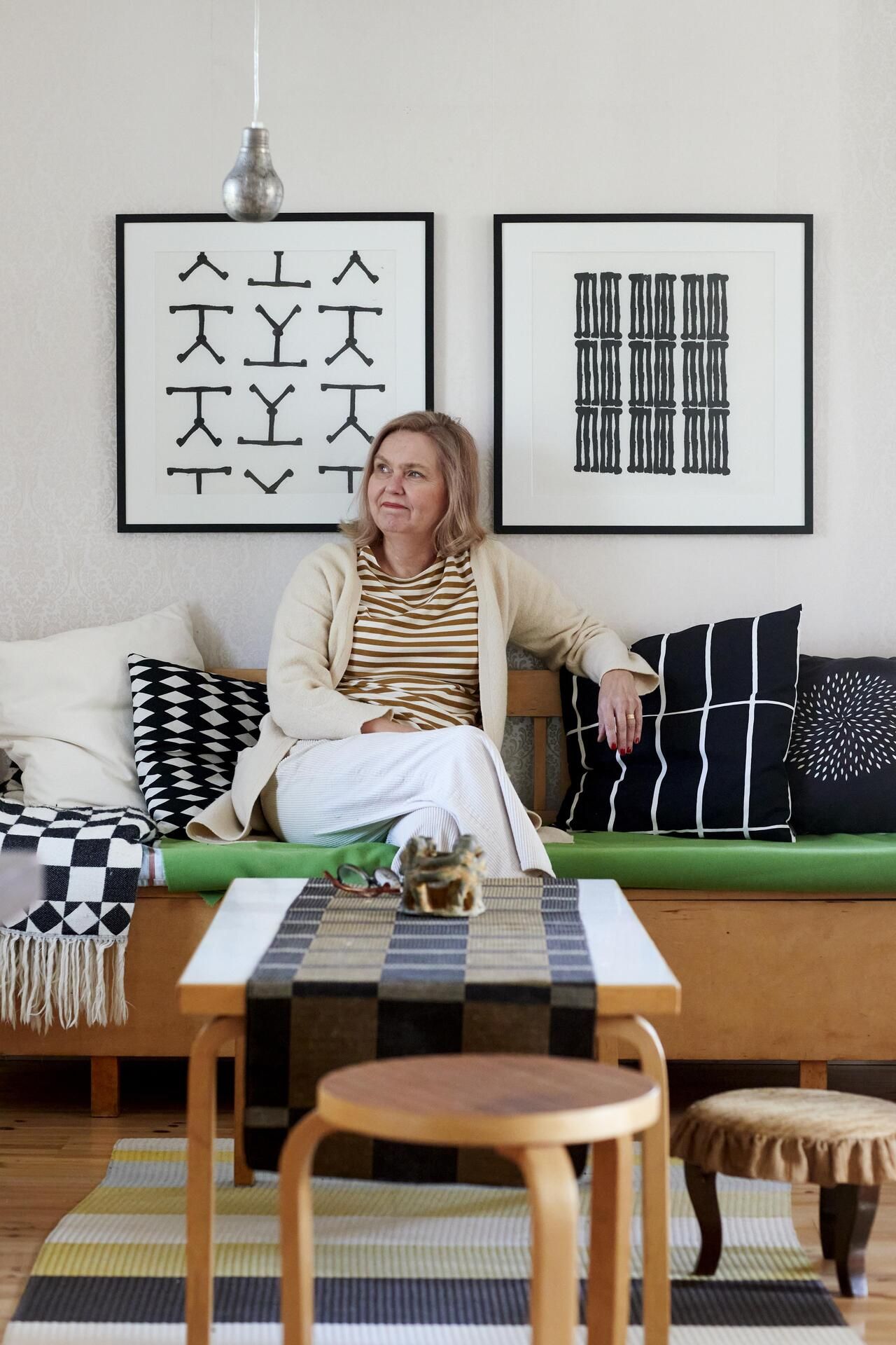 ”Taiteen tekeminen ei ole terapiaa, mutta se on aina auttanut minua jäsentämään ajatuksiani. Kuvioiden tekeminen kankaalle on minulle tapa saada asiat paikoilleen, kuvio kerrallaan”, Laura Isoniemi sanoo. Taustalla näkyvät taulut ovat hänen tekemiään.