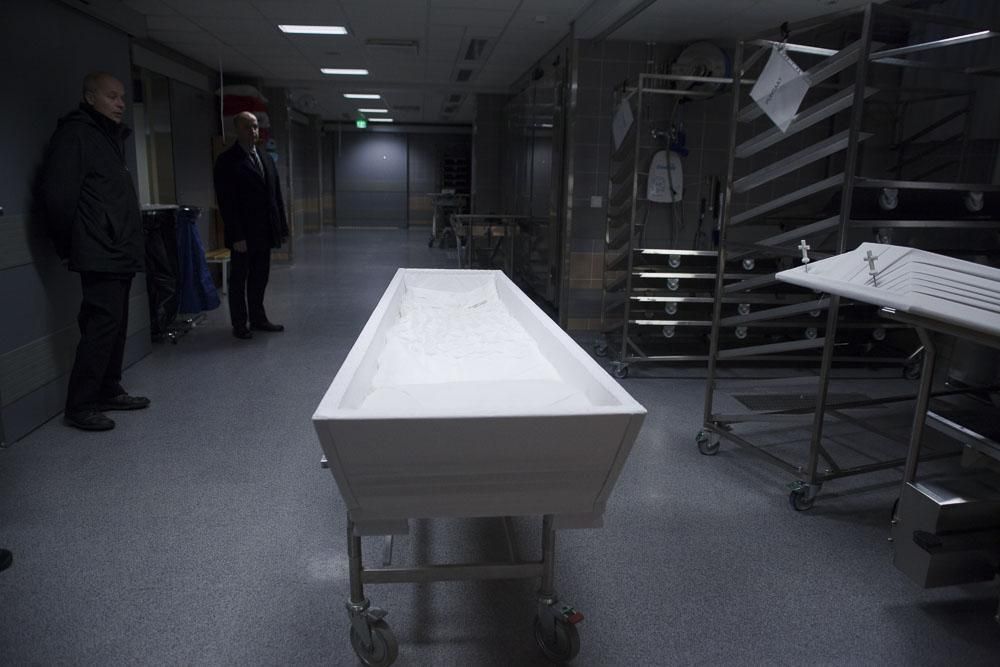 Vainaja valmistellaan arkkuun sairaalan kylmiössä.