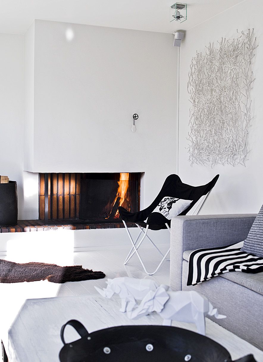 Yläkerran olohuoneen avotakka henkii talon alkuperäistä 1960-luvun tyyliä. Henriikka kasasi lepakkotuolin takana olevan seinäkoristeen Vitran pienistä muovioksista, jotka on alkujaan tarkoitettu tilanjakajiksi.