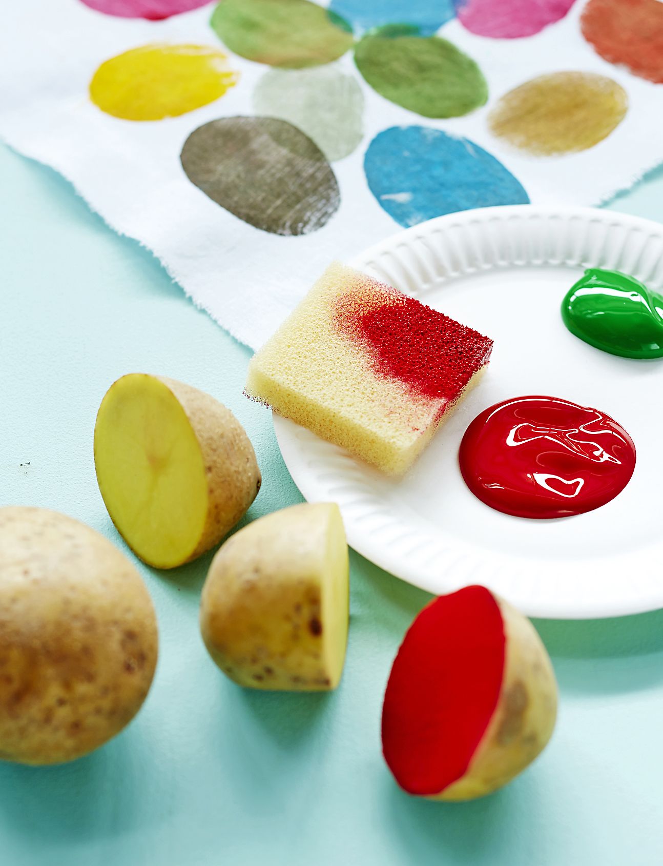 Kokeile värejä tilkulle ennen kuin kuvioit tyynykankaan. Aloita painamalla pottujen kuvia puhtailla väreillä. Sekoita sitten lautasilla olevista väreistä uusia sävyjä.