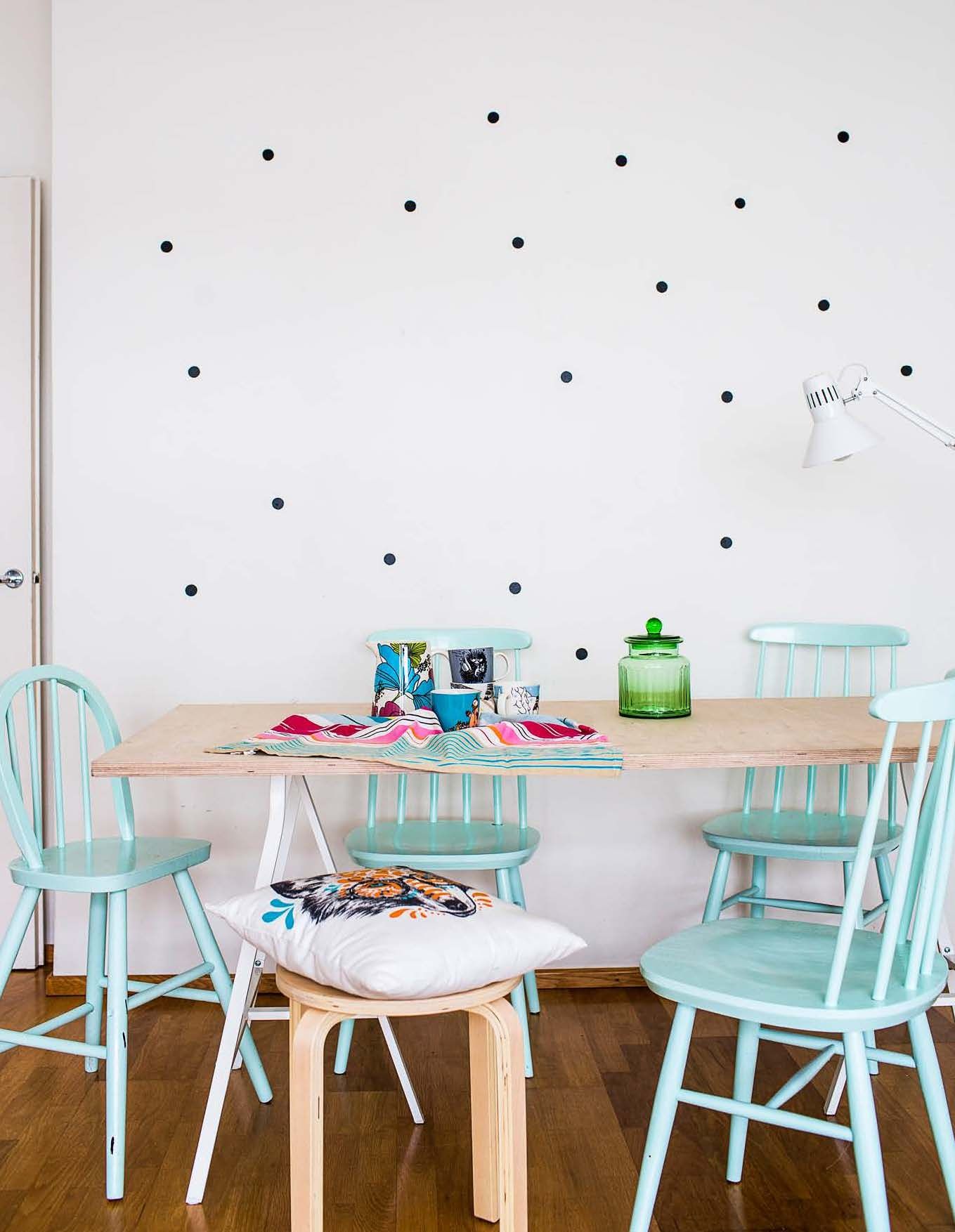 Vuokra-asuntoon sopivat helposti muunneltavat sisustusjutut. Olohuoneen valkoista seinää piristin tarrakalvosta leikkaamillani mustilla palloilla. Pöytä syntyi Ikean metallisista jaloista ja tilaamastani vanerilevystä. Pinnatuolit löytyivät hylättynä kellarista.