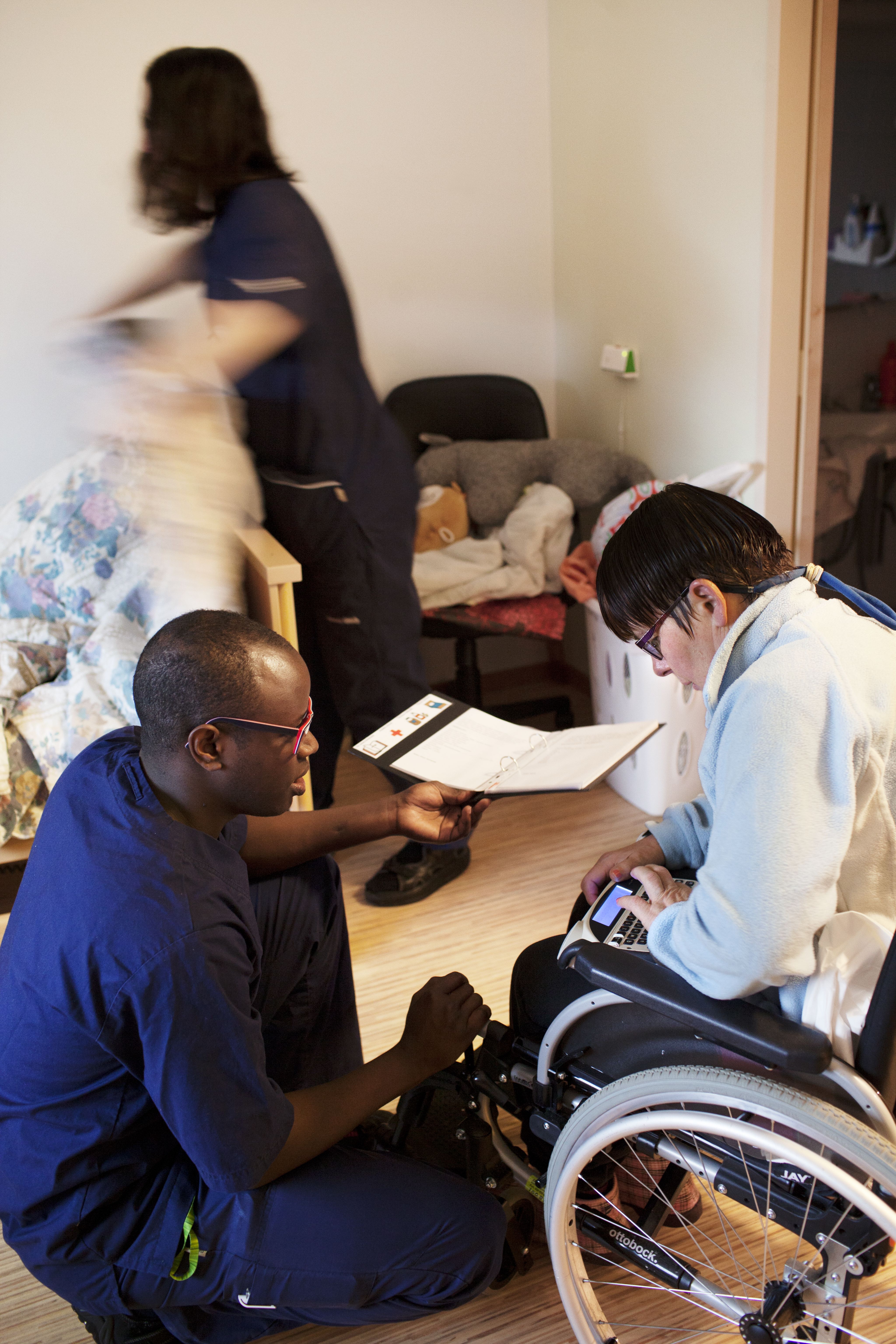 Keskustelu Taina Tuonosen kanssa sujuu puhekoneella. Lähihoitaja Anna Hovi sijaa vuoteen.