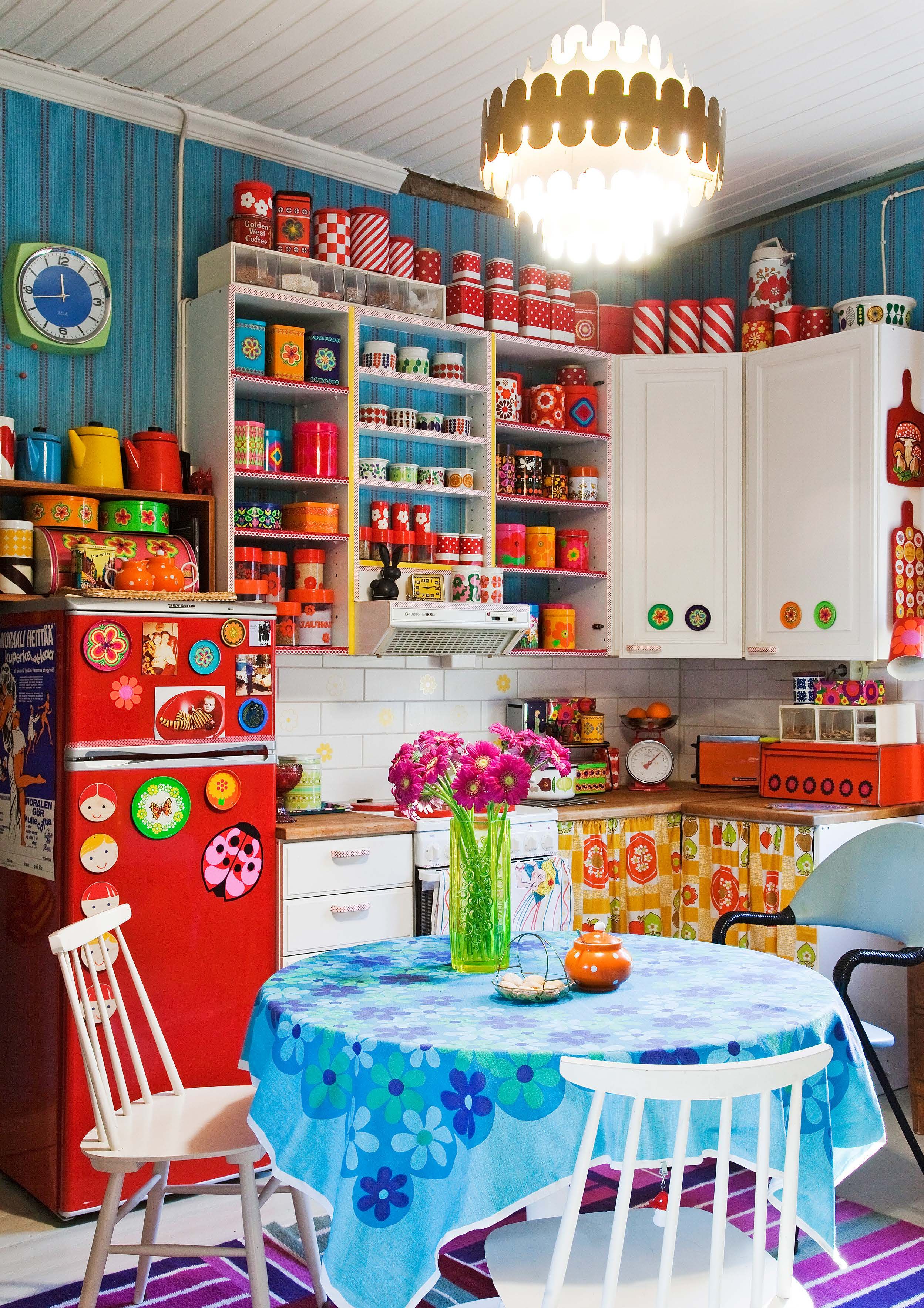 Keittiö on kuin pieni putiikki. Hyllyiltä voi bongata Esteri Tomulan suunnittelemia kattiloita, monille lapsuudesta tuttuja emalimukeja ja Fazerin karkki- tai kaakaopurkin. Kevytrakenteinen nojatuoli on kirpputorilta.