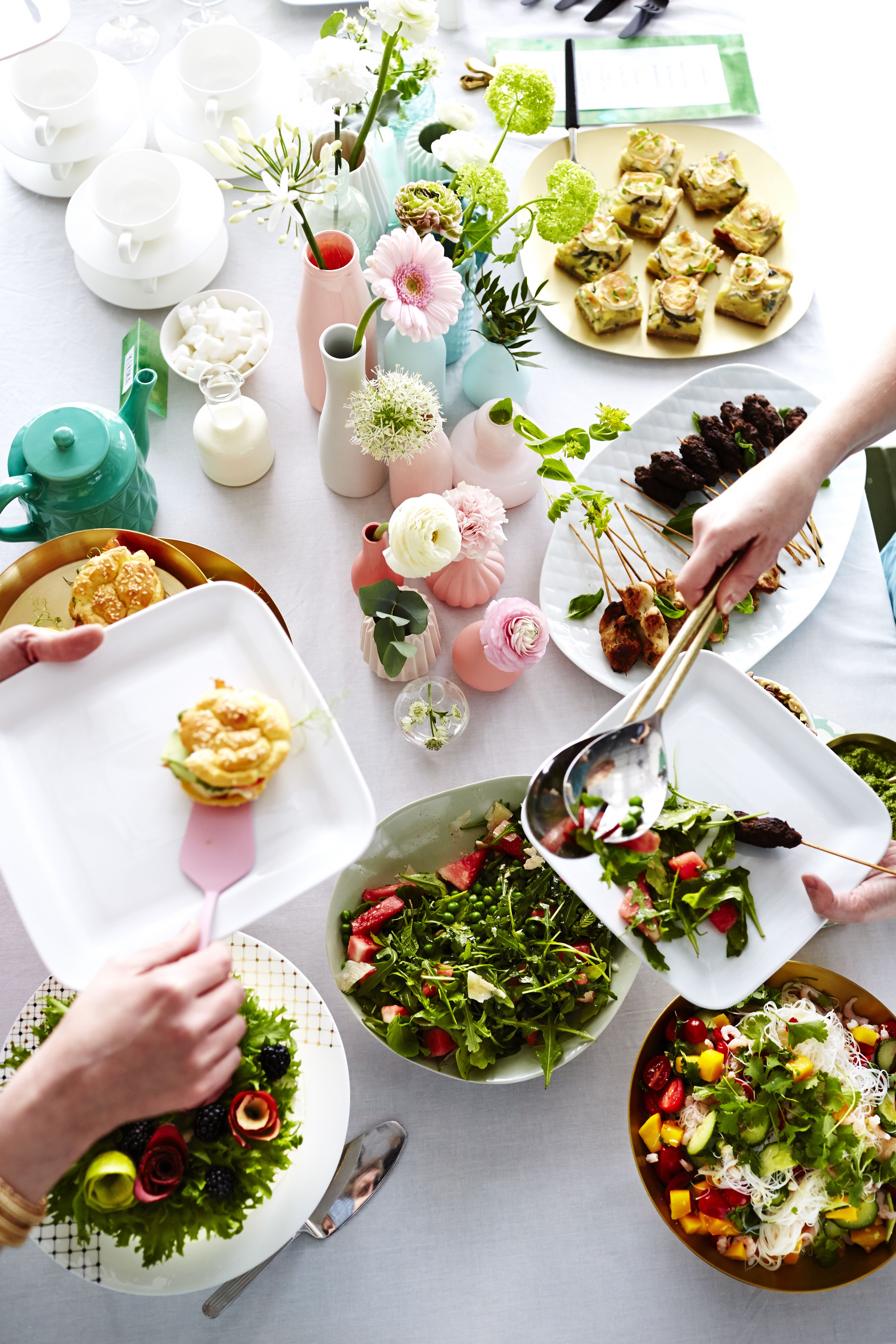 Juhlapöydän kukka-asetelmaan saa näyttävyyttä käyttämällä erikokoisia ja -korkuisia maljakoita.