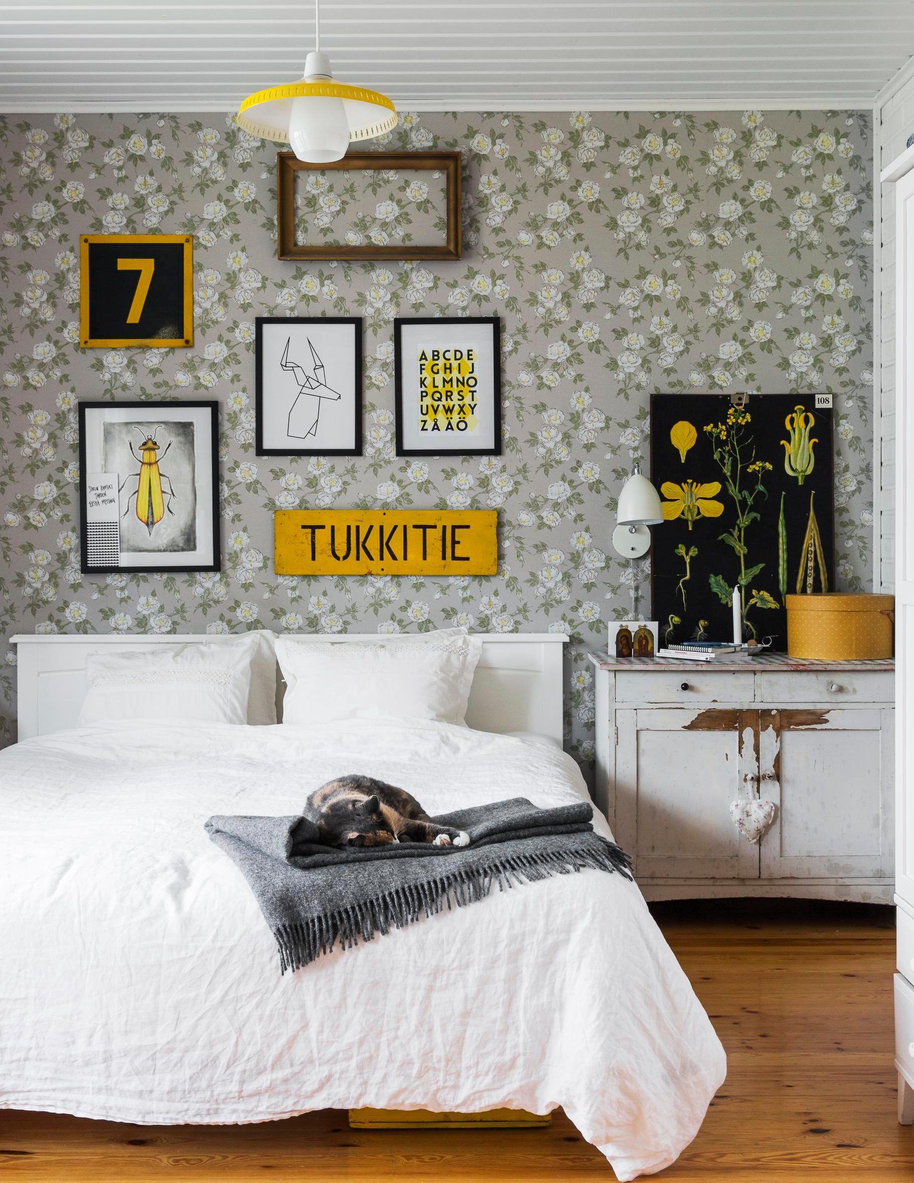 Makuuhuoneen tapetti on Tapettitalon Juhannusruusu. Vuoteen ylle ripustettu Tukkitiekyltti löytyi Karhulasta Onni-nimisestä vanhan tavaran liikkeest