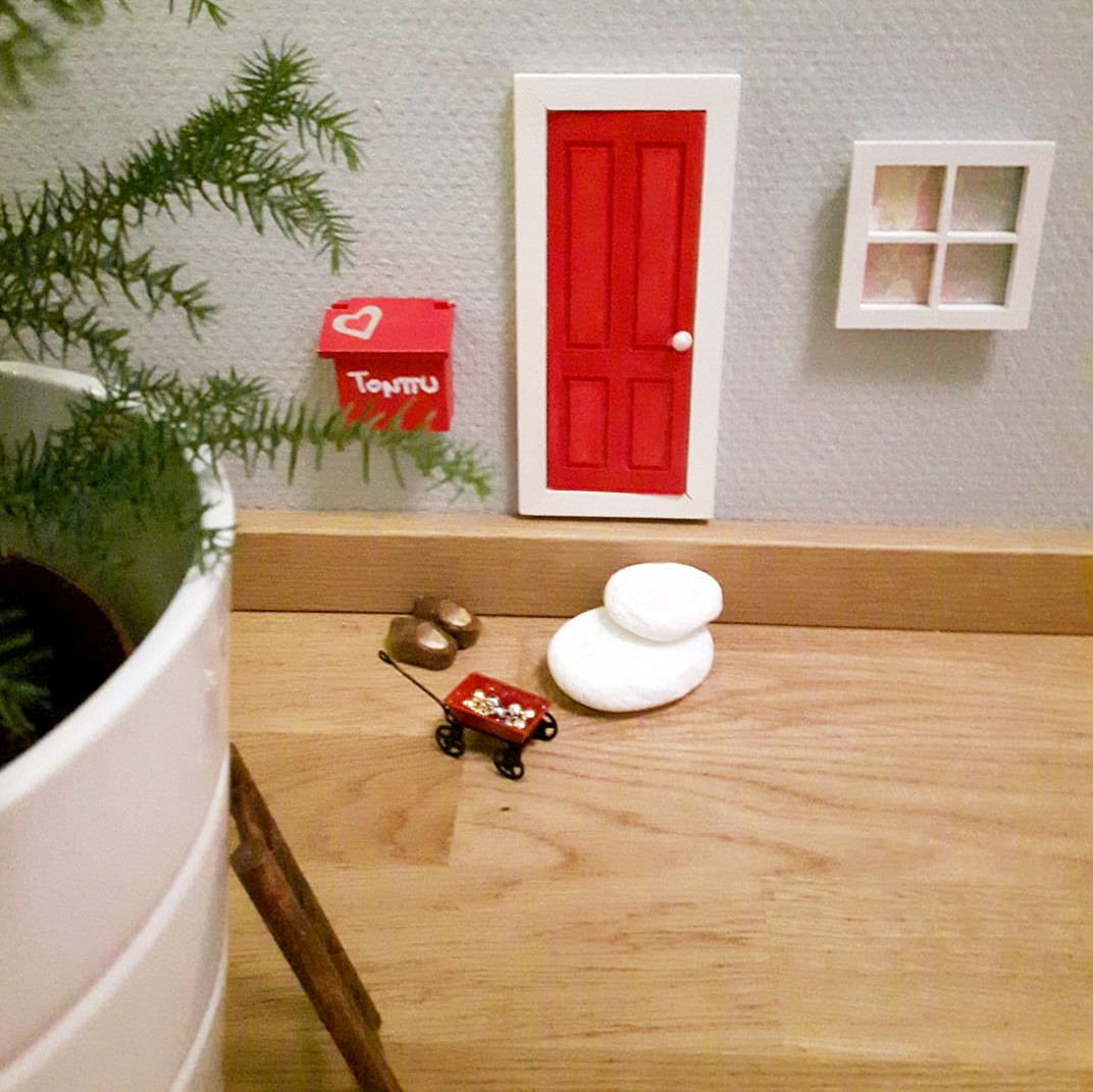 "Ovi, postilaatikko, tontun kengät ja tikkaat ovat askartelukaupasta, mutta maalasin ne itse. Ikkuna on tilattu Wish-nettikaupasta- Liimasin sinne joulukortista kuvan. Tonttu rakentaa kun kiireiltään kerkeää. Ikkuna ilmestyi viime yönä. Tonttu toimii myös joulkalenterin täyttäjänä ja koristeli jo huonekuustakin." Hanne Helasuo