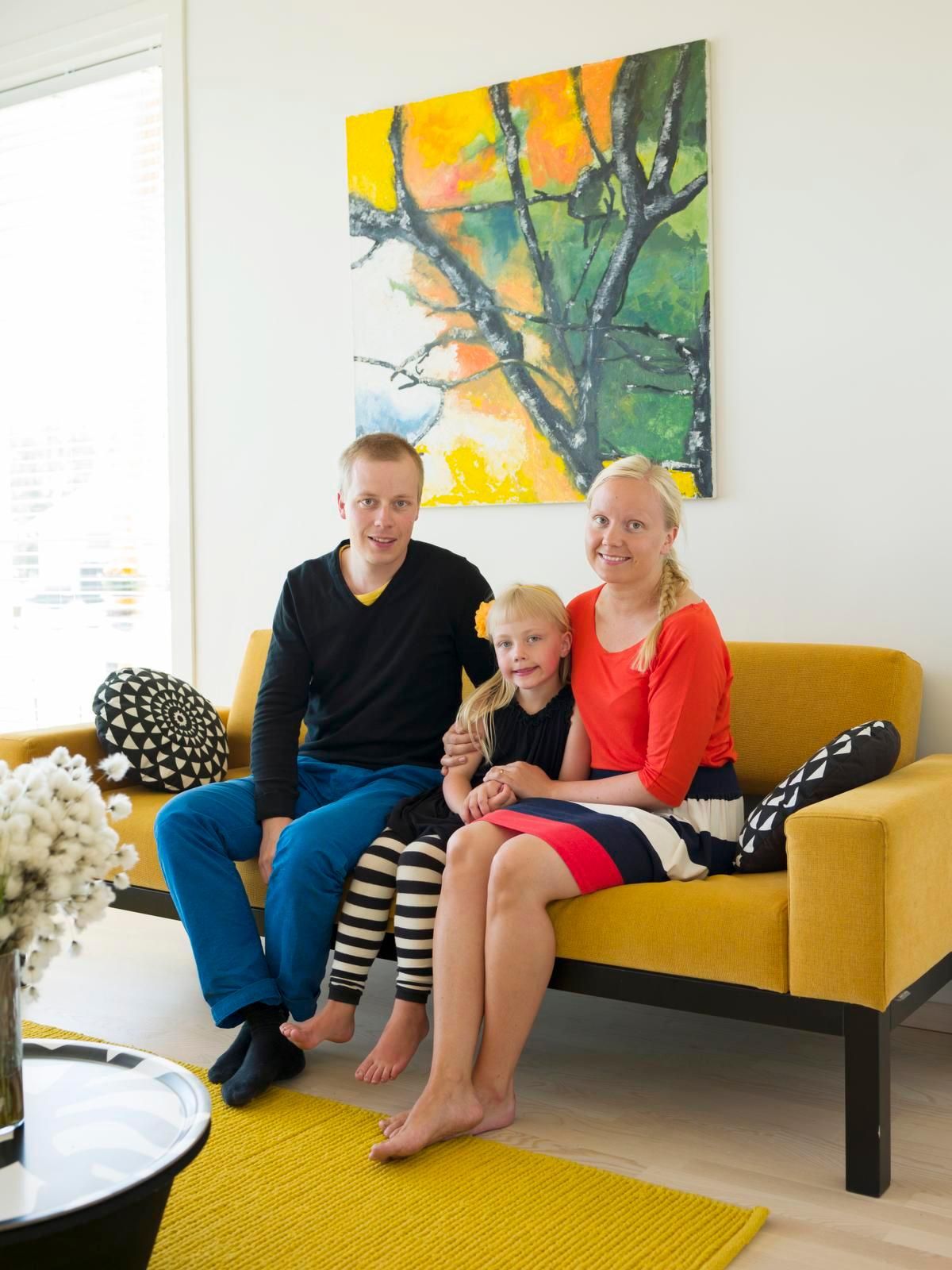 Teemu, Siiri ja Lotta viihtyvät värikkäässä kodissa. Sohva on Lundian ja pöytä Marimekon Kirstu. Öljyvärimaalaus on nimeltään Elämänpuu.