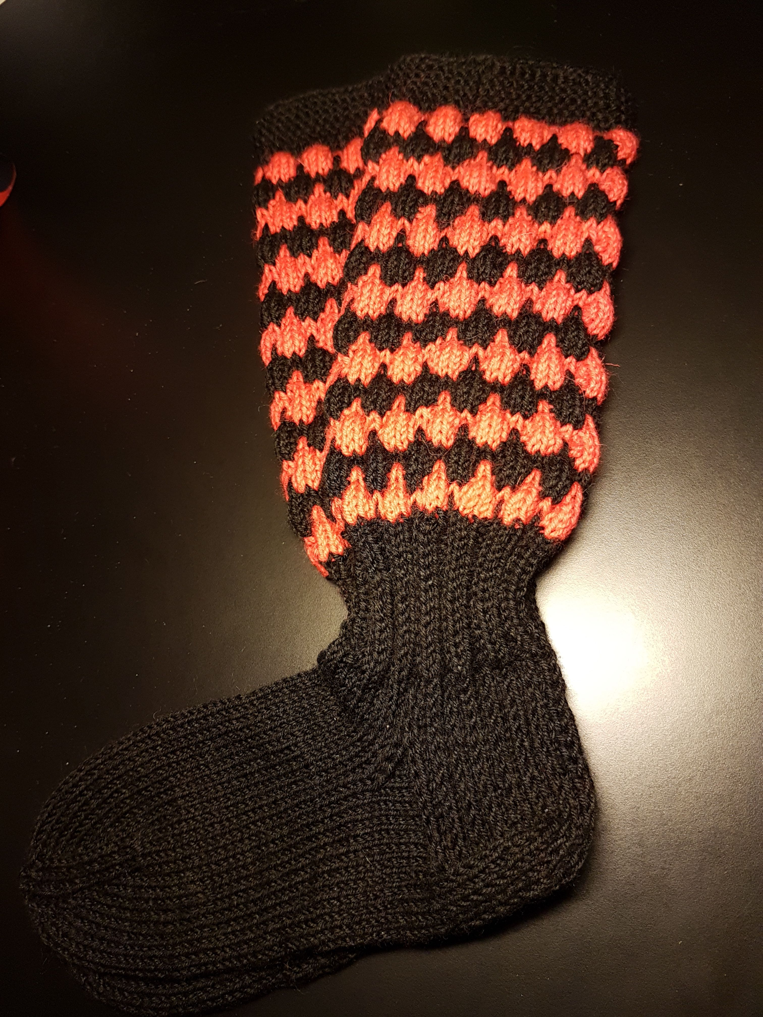 "Vanhempani ovat Karjalasta. Olen käynyt Ruskealassa ja muualla Karjalassa useita kertoja. Sukkia kudon paljon viidelle lapsenlapselleni ja aikuisille. Halusin tehdä Karjalan väreillä, ja kuplaneulos sopi tähän hyvin. Punainen näyttää kuvassa oranssilta, mutta on punainen, ei kuitenkaan täysin kirkas punainen." – Evakon lapsi