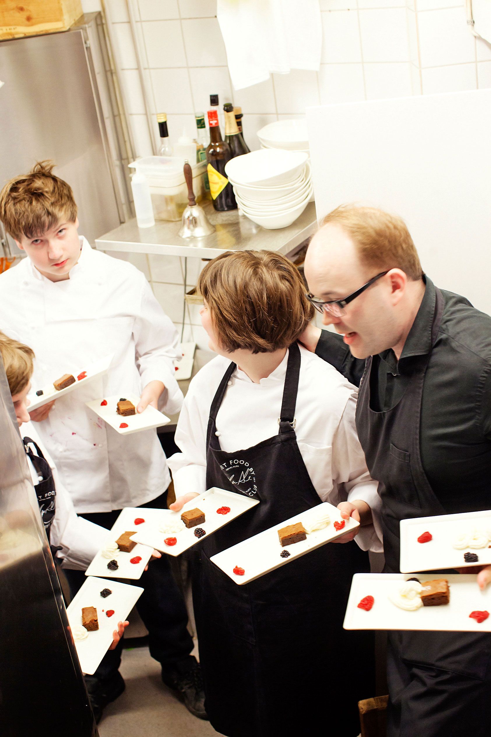 Browniet tuodaan jälkiruuaksi yhtä aikaa koko pöydälle. Keittiöstä saliin lähdössä Elli Piiponniemi, Joakim Nurkki, Ella Mäkelä ja Mikko Haakana.