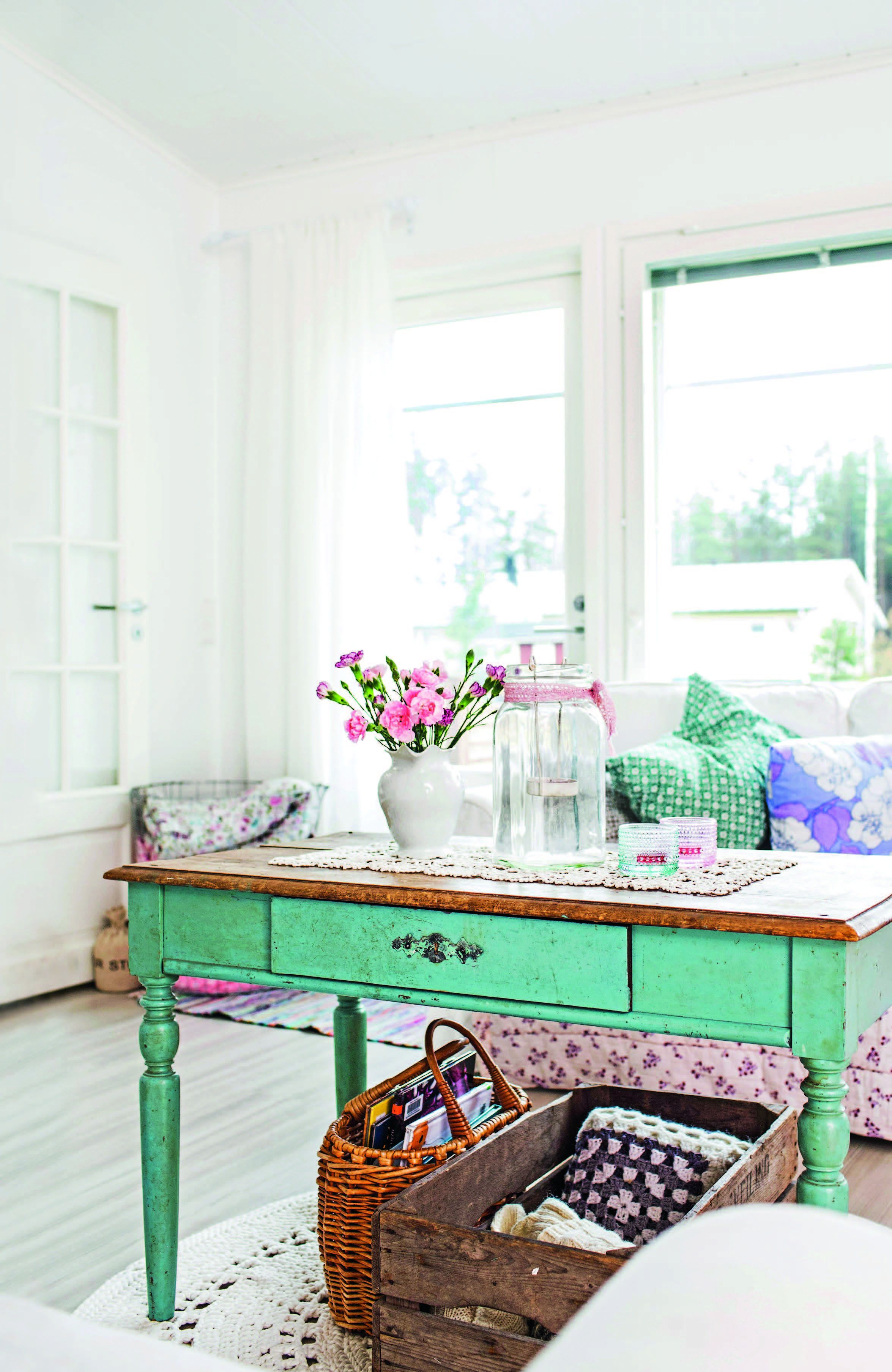 Täydellisen vihreä pöytä hellytti Annin hylkäystarinallaan. Vanhat puulaatikot palvelevat lehti- ja halkolaatikkoina.