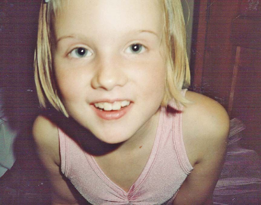 Koululainen poseeraa balettipuvussa.