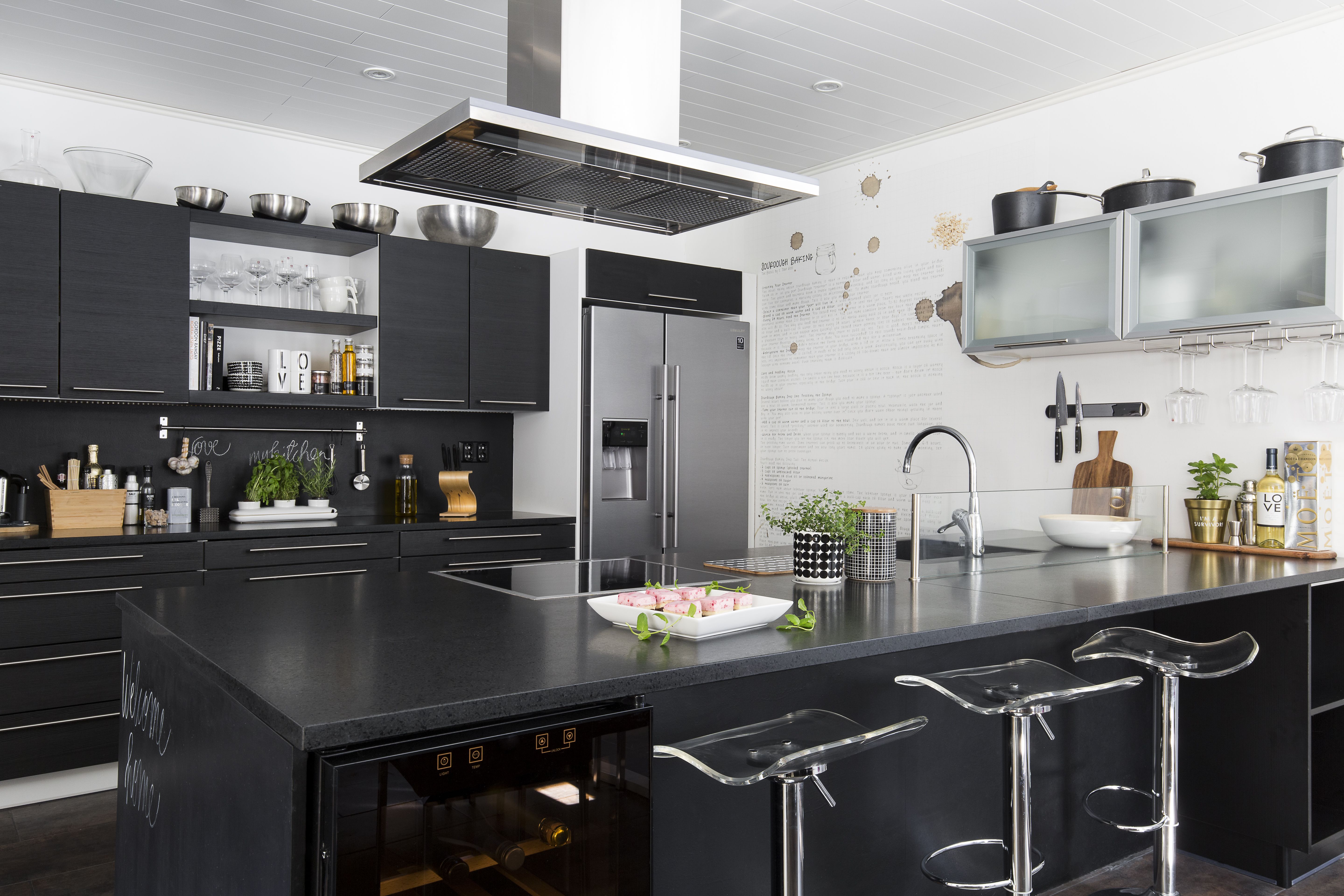 Puustellin keittiön kivitasot ovat helppohoitoiset. Saarekkeen ansiosta kokki voi puuhatessaan rupatella vieraiden kanssa.