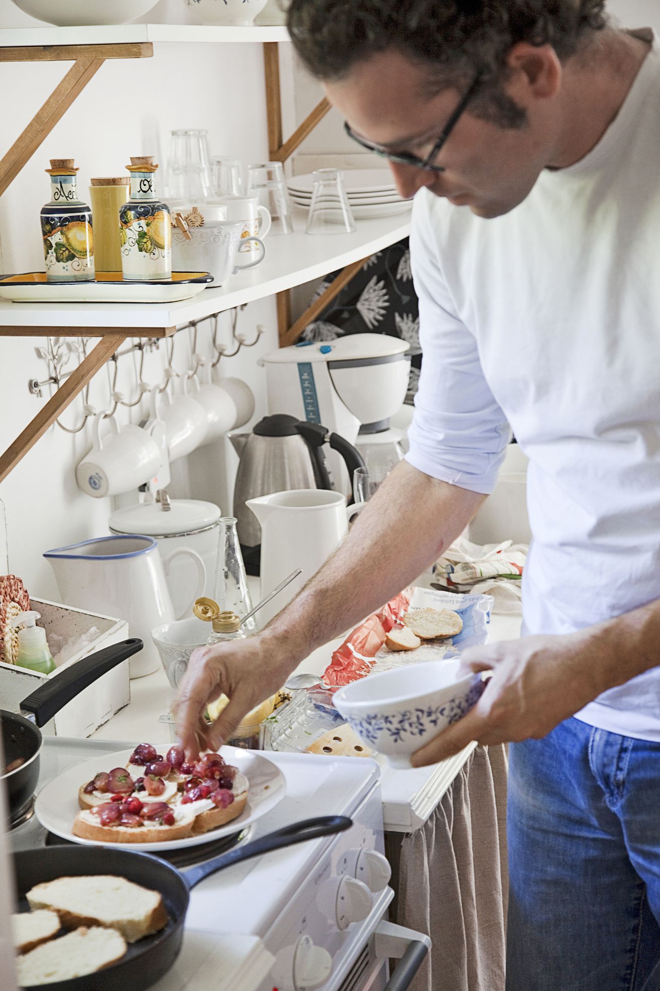 Gabriele laittaa bruschettat ­uuniin. Italialainen arkkitehti on lumoutunut kesäpaikan hiljaisuudesta.