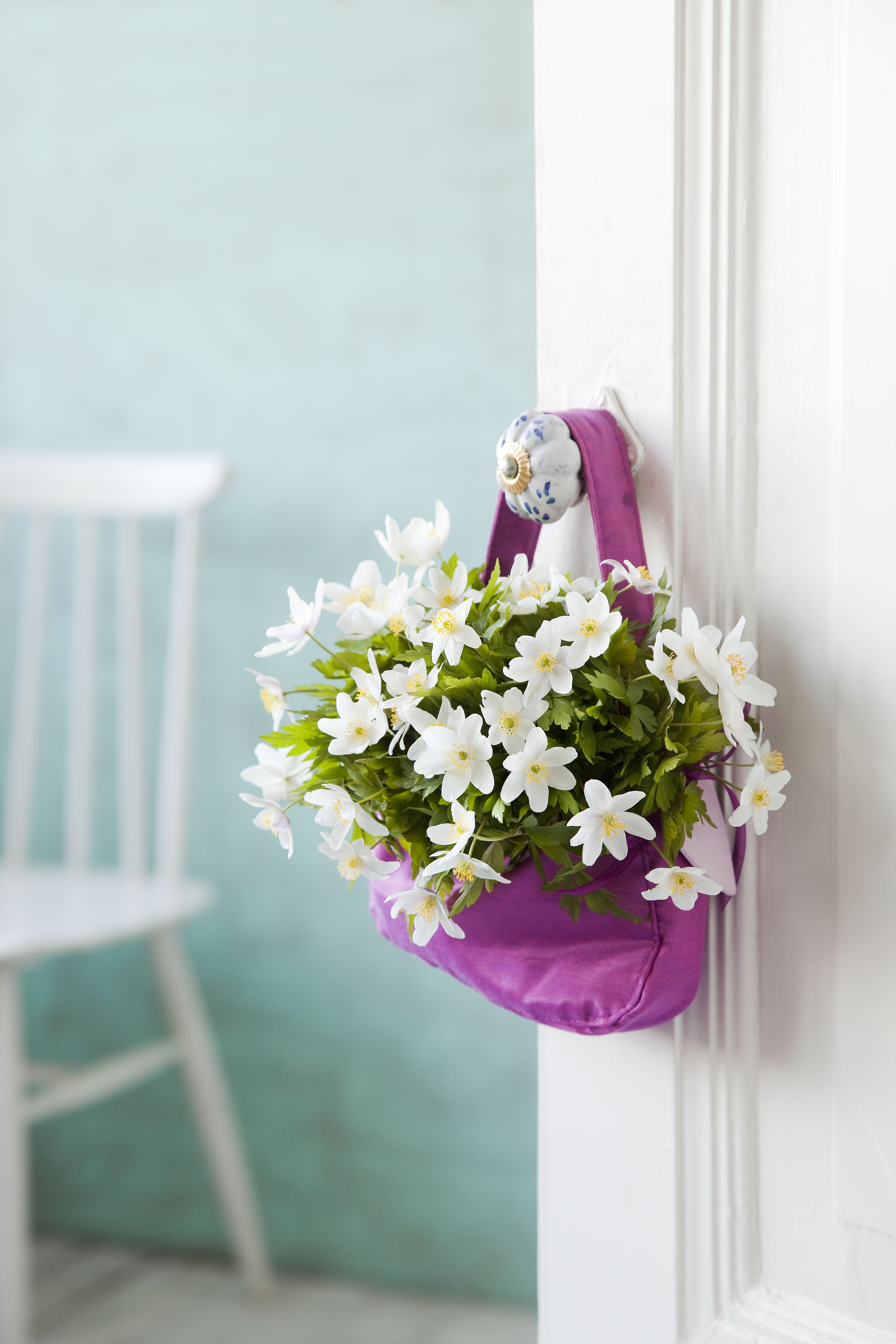 Pörheä kimppu valkovuokkoja ovenkahvassa toivottaa suloisesti tervetulleeksi.