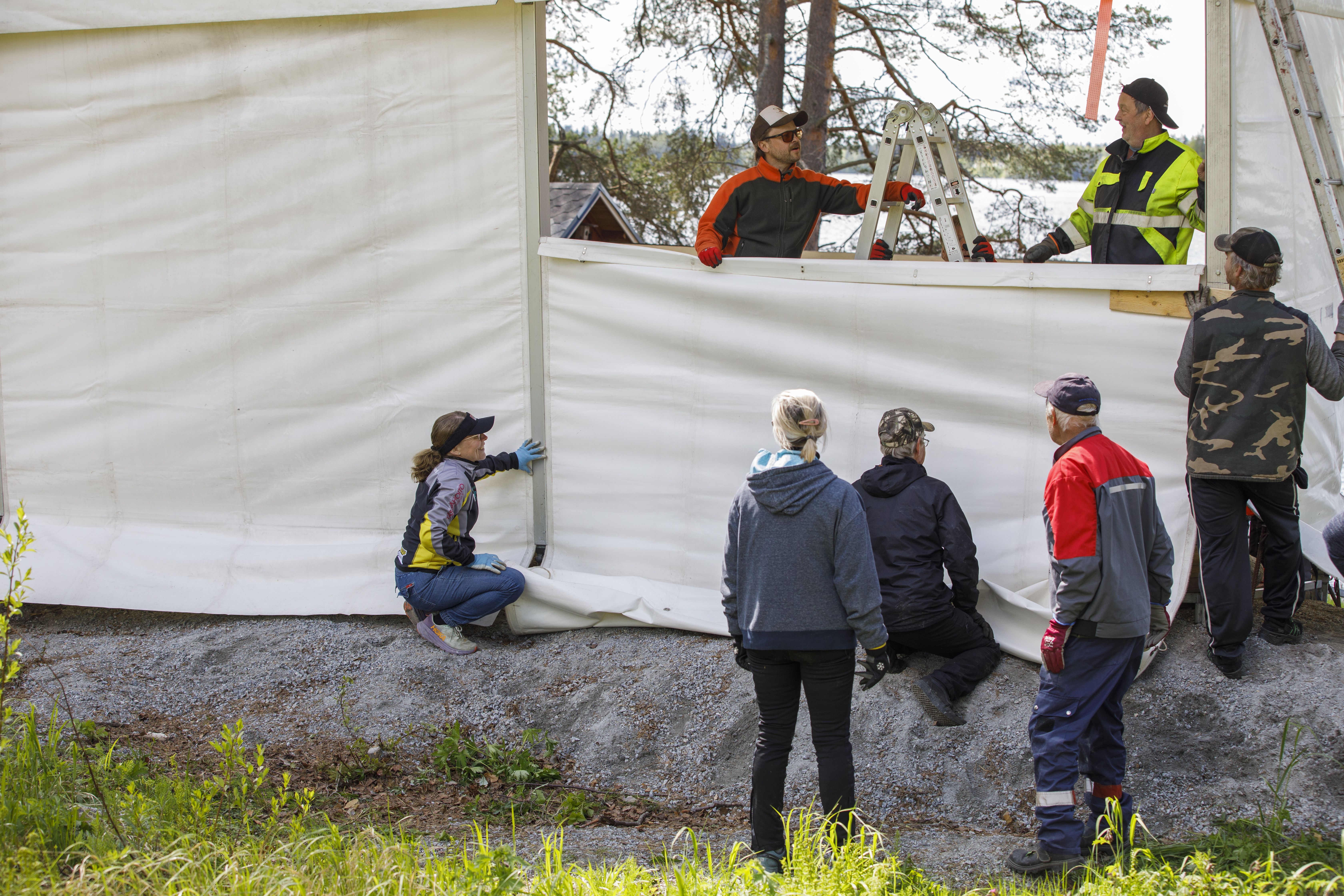 Tästä kesä käynnistyy. Juha Varis (ylhäällä vasemmalla) ja talkooporukka pystyttämässä Löytänän kesäteatterin katsomon katetta.
