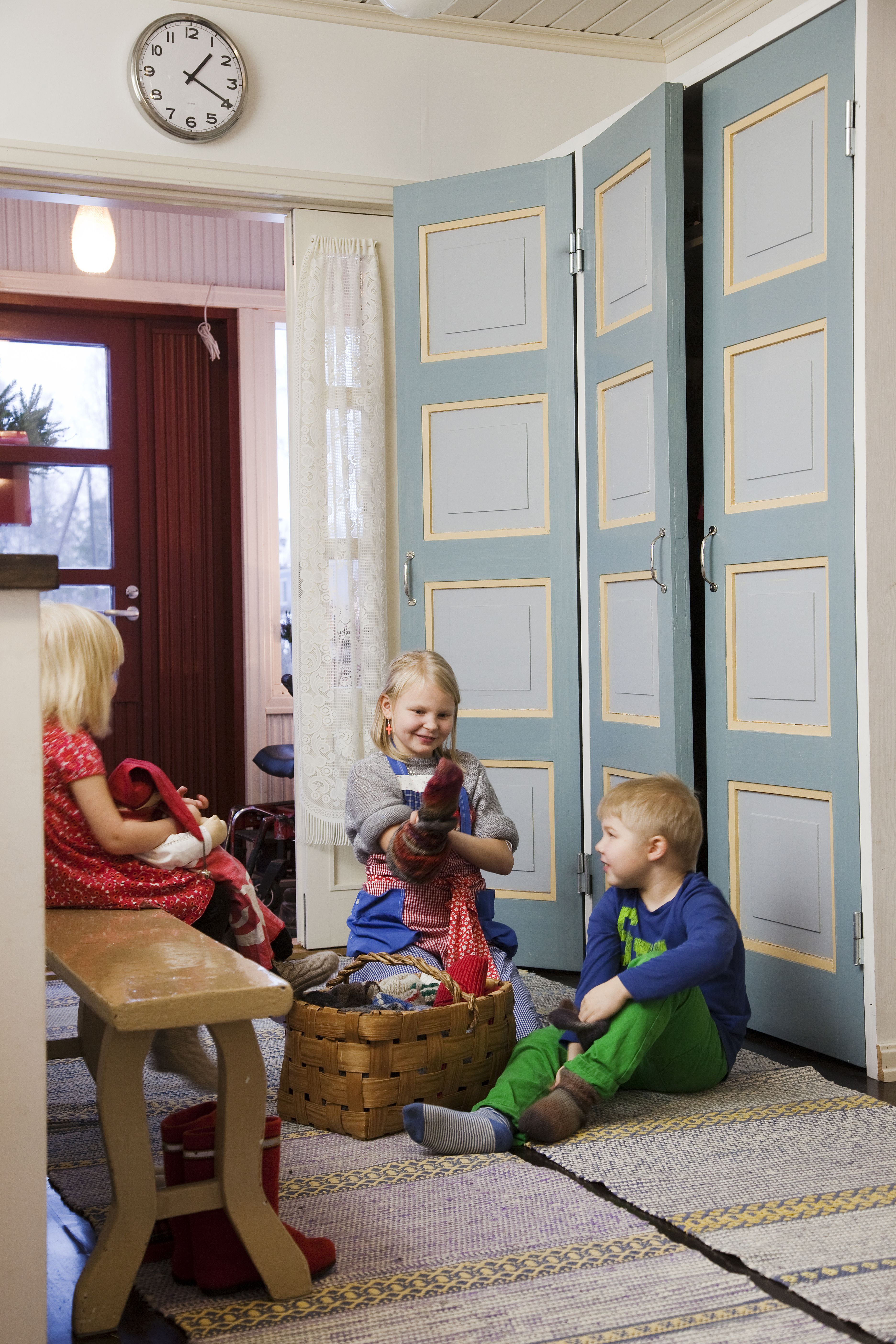 Eteisen villasukkakori on konkreettisen lämmin tervetulotoivotus. Lapset valitsevat korista ne sukat, joissa on heidän lempivärejään. Eteisen komeroiden ovet löytyivät purkutyömaalta.