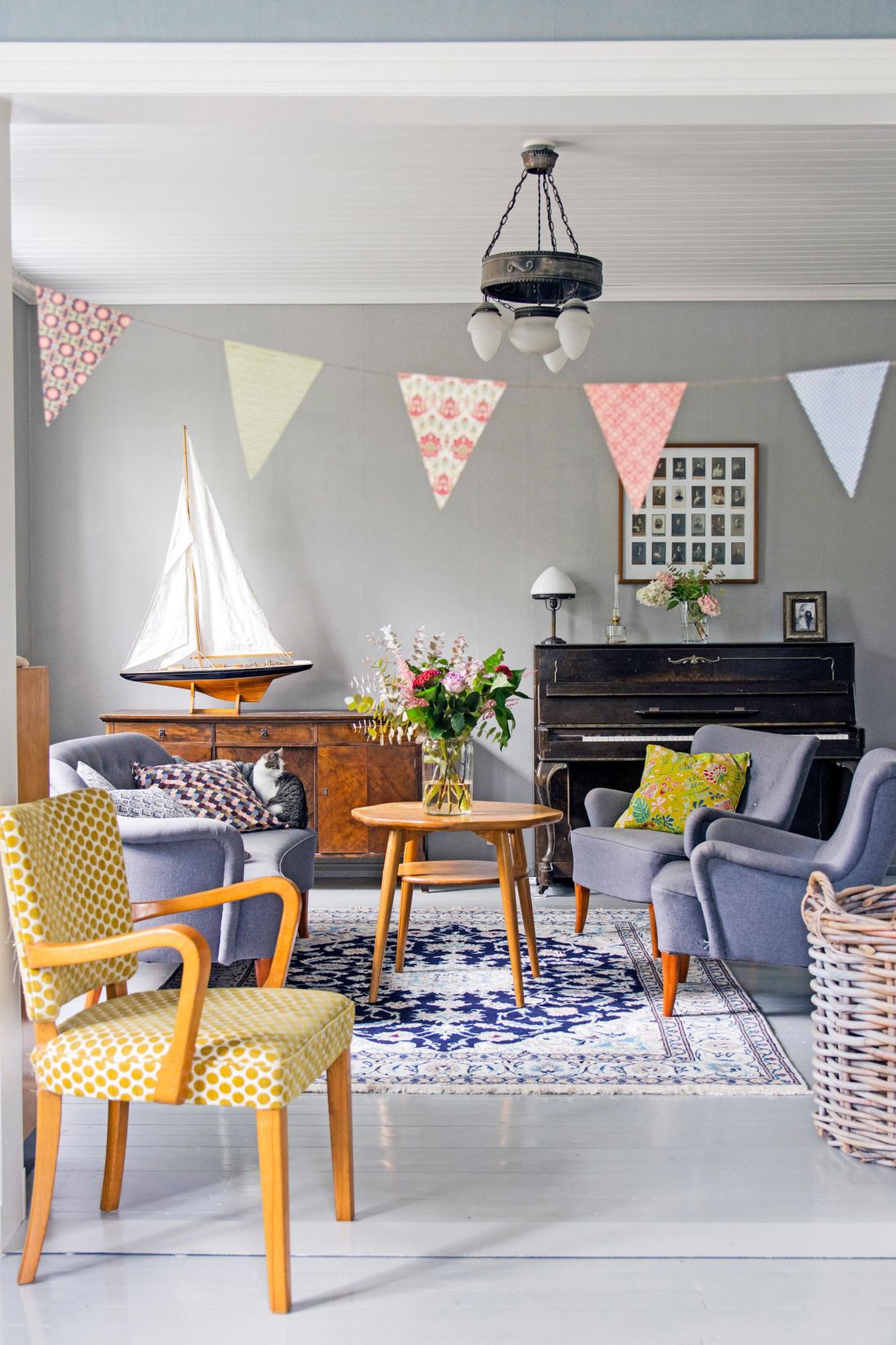 Olohuoneen rauhallinen mutta iloinen tunnelma on luotu harmaan ja keltaisen sävyillä.