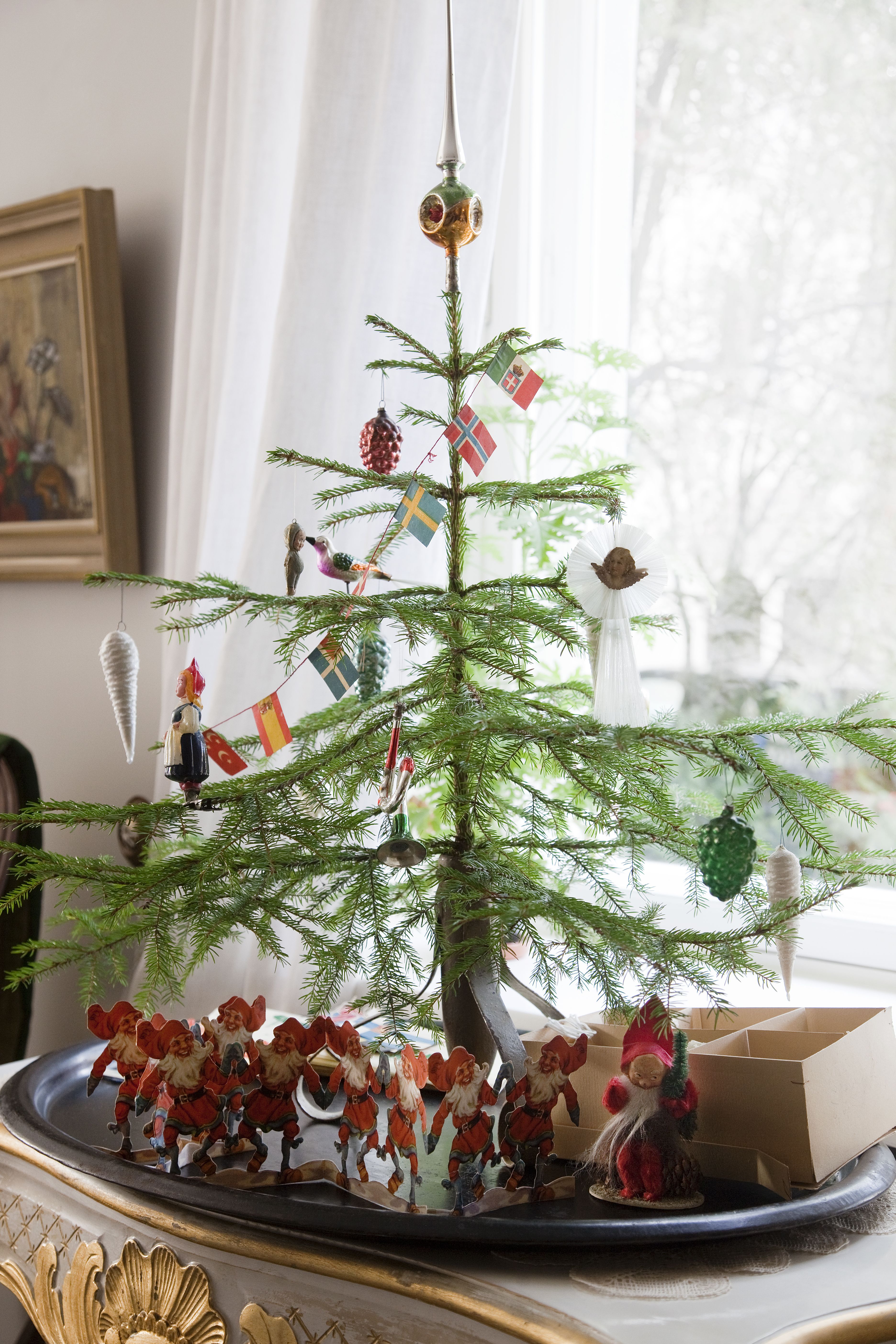 Makuuhuoneen pöytäkuusessa on vanhoja lasikoristeita. Verhoiksi Piritta löysi antiikkimessuilta vanhat ranskalaiset morsiuslakanat.