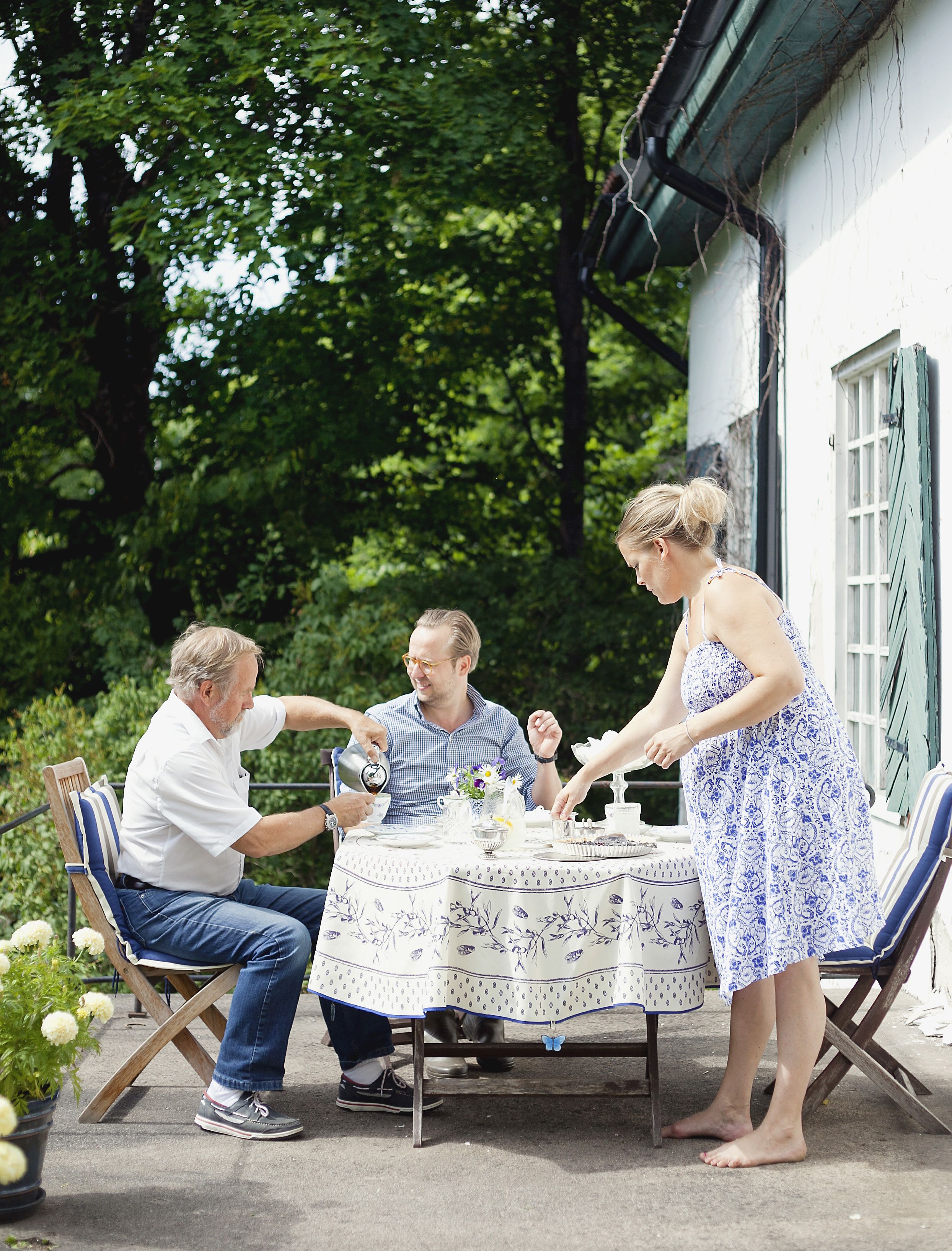 Patrick, Sofia ja Sofian isä Johan Lund (vas.) juovat terassilla iltapäiväkahvit mustikkapiirakan kera. 