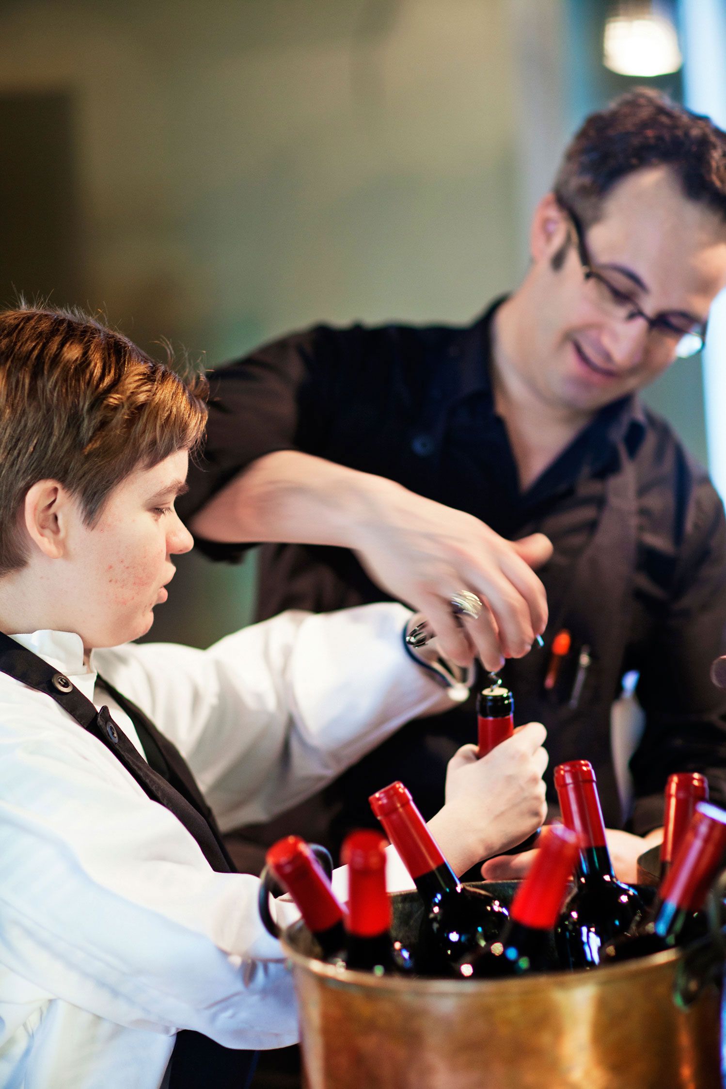 Sommelieerit työssään. Samuil Angelov neuvoo Petra Isoniemelle, kuinka viinipullo avataan.