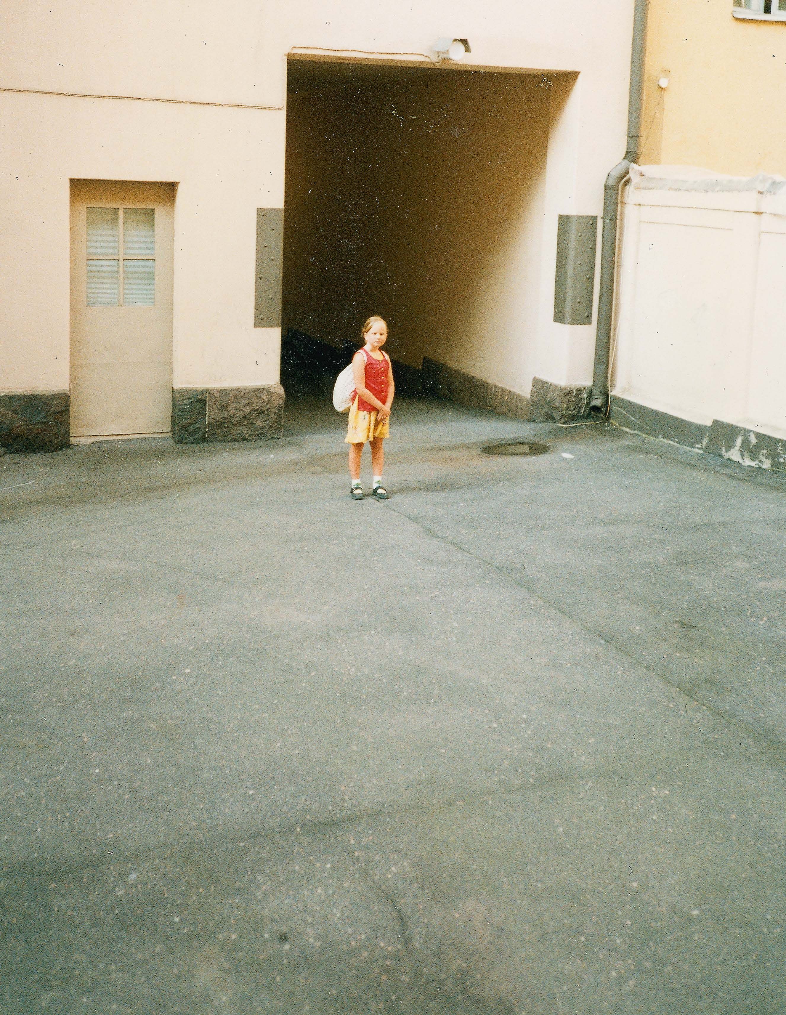 Koululainen äidin kodin sisäpihalla. Isän luokse oli lyhyt kävelymatka.