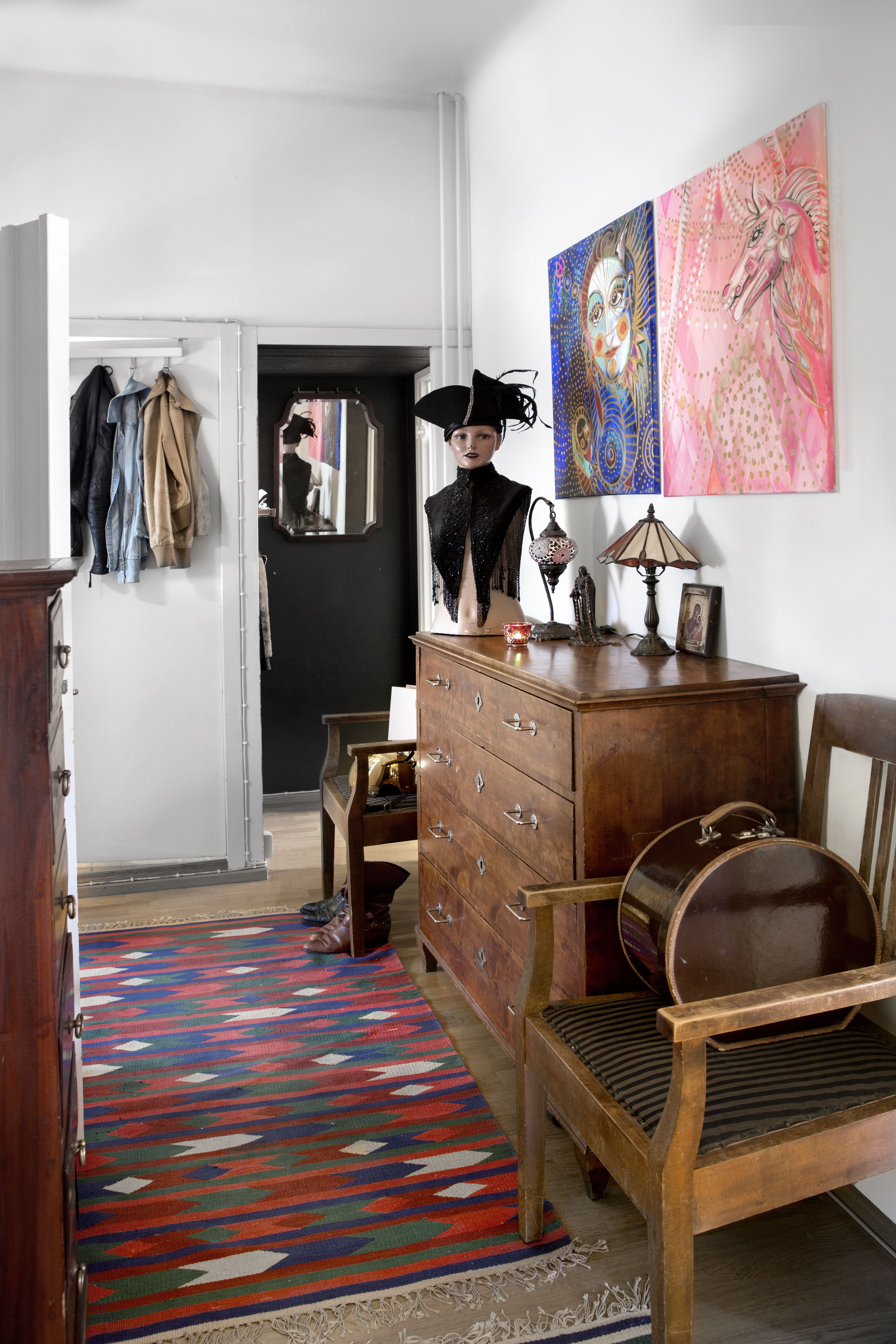 Eteisen kalusteet ovat antiikkia, matot kirpputorilta ja maalaukset Irjan itse tekemiä. Hatturasiassa hän säilyttää vöitään.