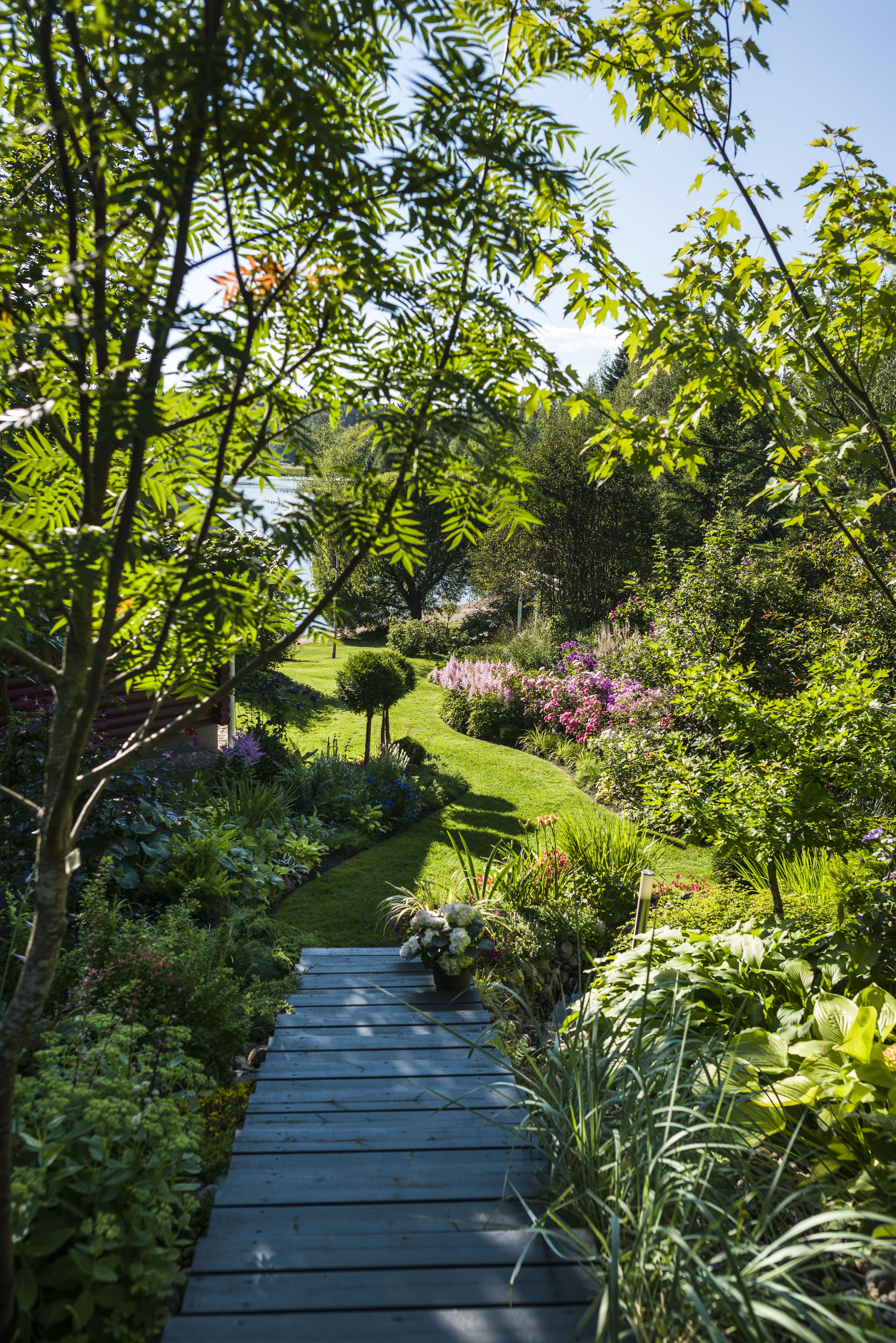 Nurmialueiden siistit rajat ovat Joukolle sydämen asia. Portaiden ylle kaartuvat tuurenpihlaja ja hopeavaahtera.