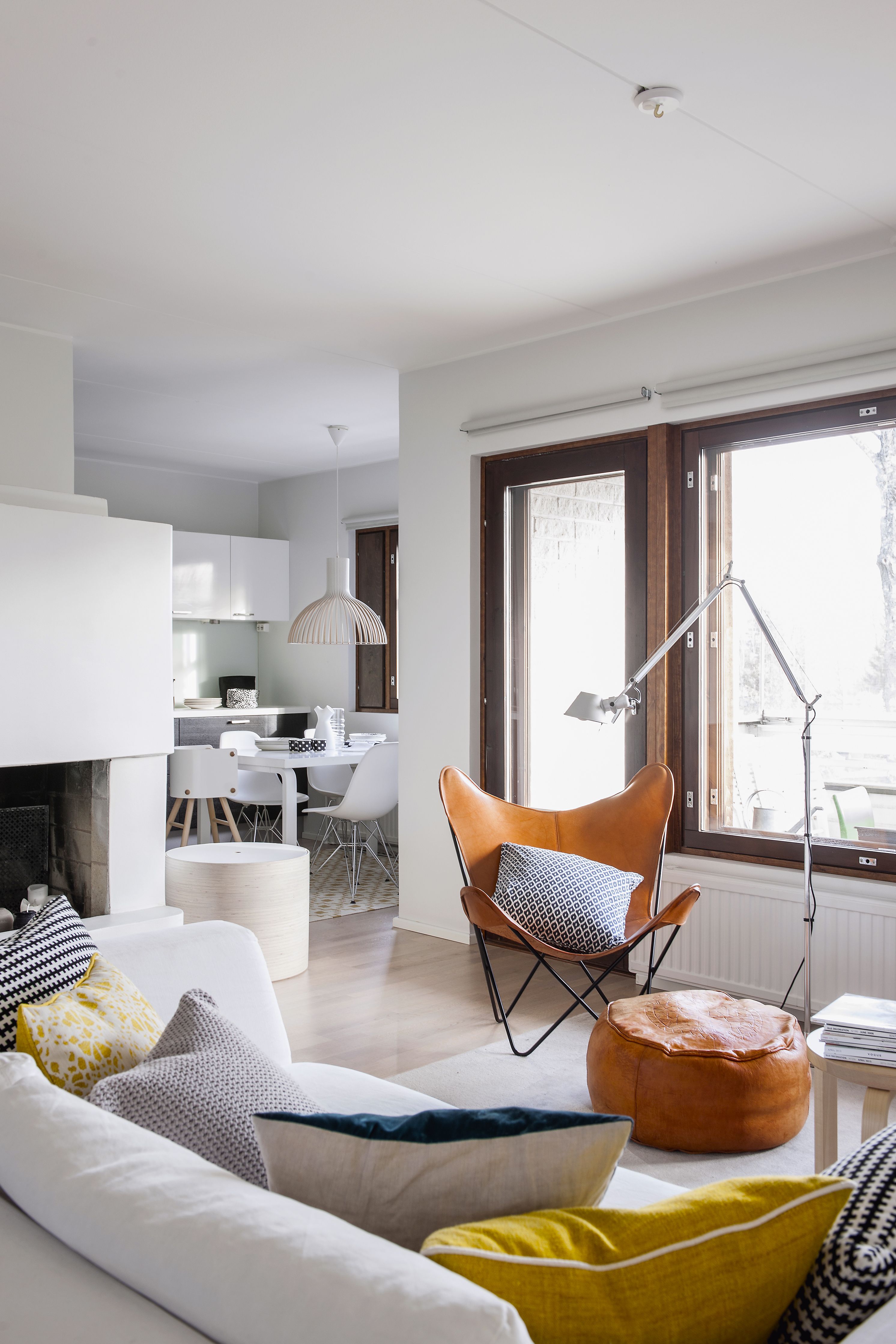  Olohuoneesta näkyy mustavalkoiseen keittiöön. Näyttävä takka on kodin sydän. Suuri parveke tuo olohuoneen jatkeena lisäneliöitä asuntoon.