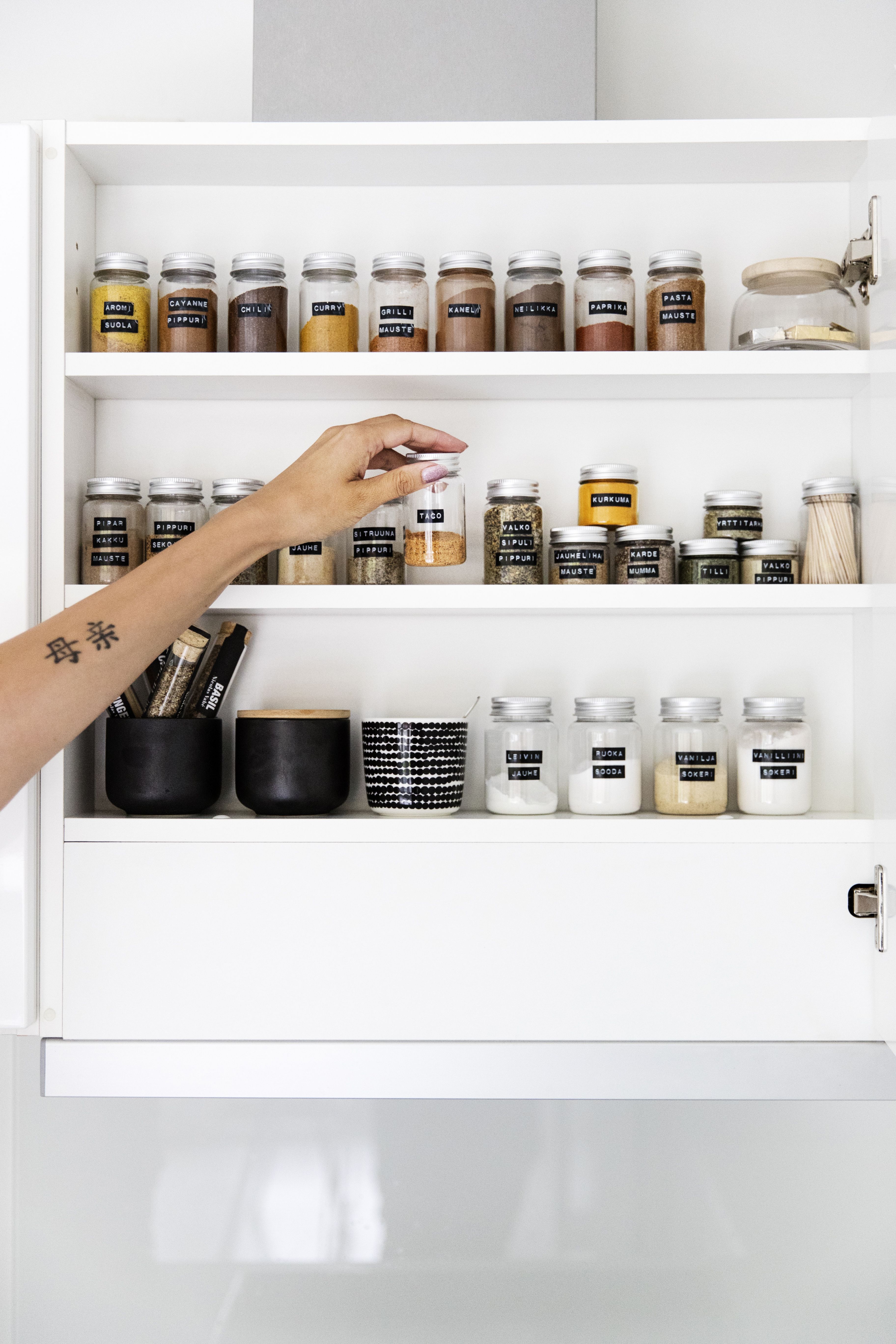 Silmä lepää maustekaapissa, jonka purkit ovat samanlaisia ja sisällöt aakkosjärjestyksessä.