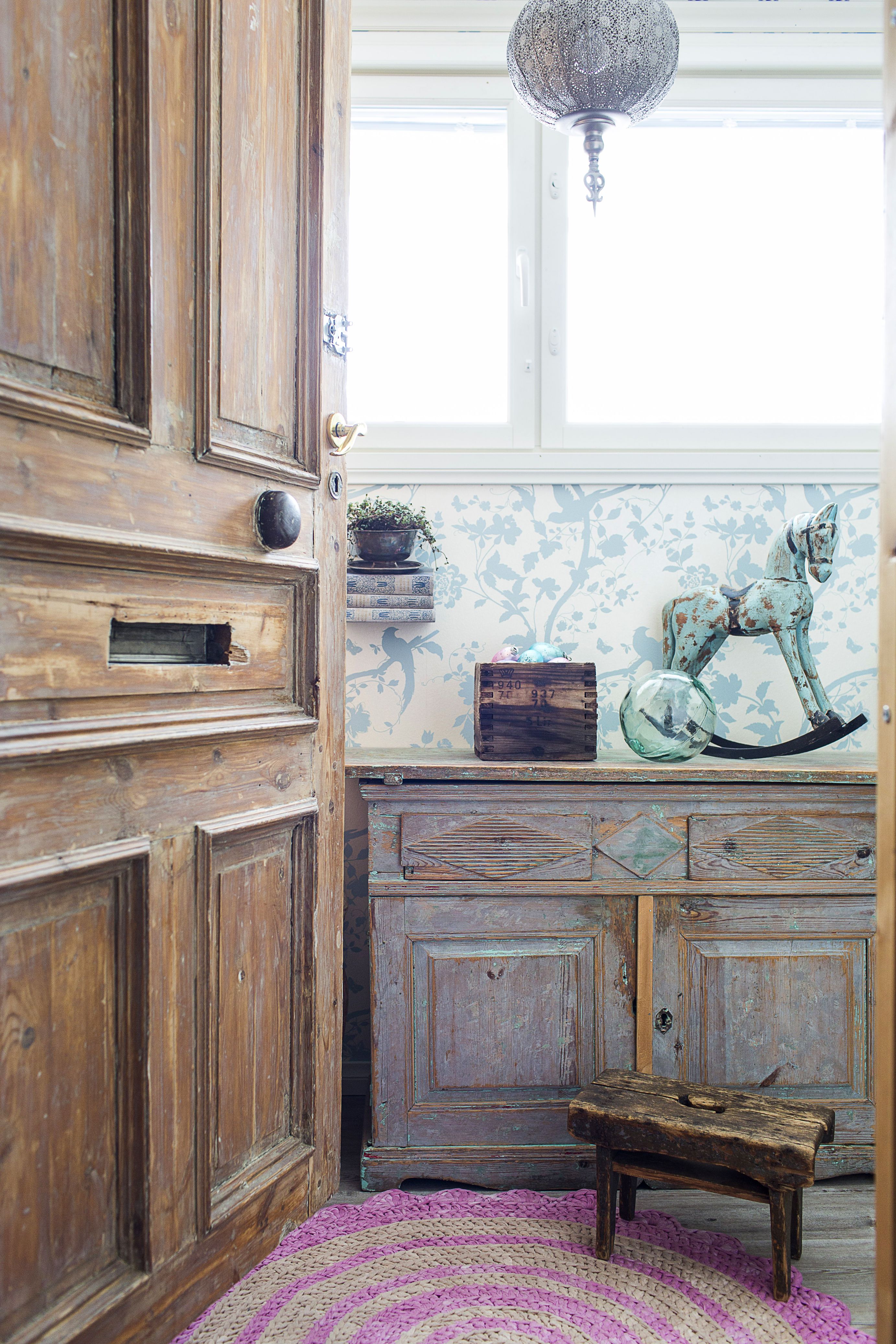 Ilona löysi vanhat kerrostalon ovet Wanhan Wallan­kumous -liikkeestä. Luukut ja ovikello muistuttavat menneestä. Lypsyjakkara viettää eläkepäiviä koristeena.