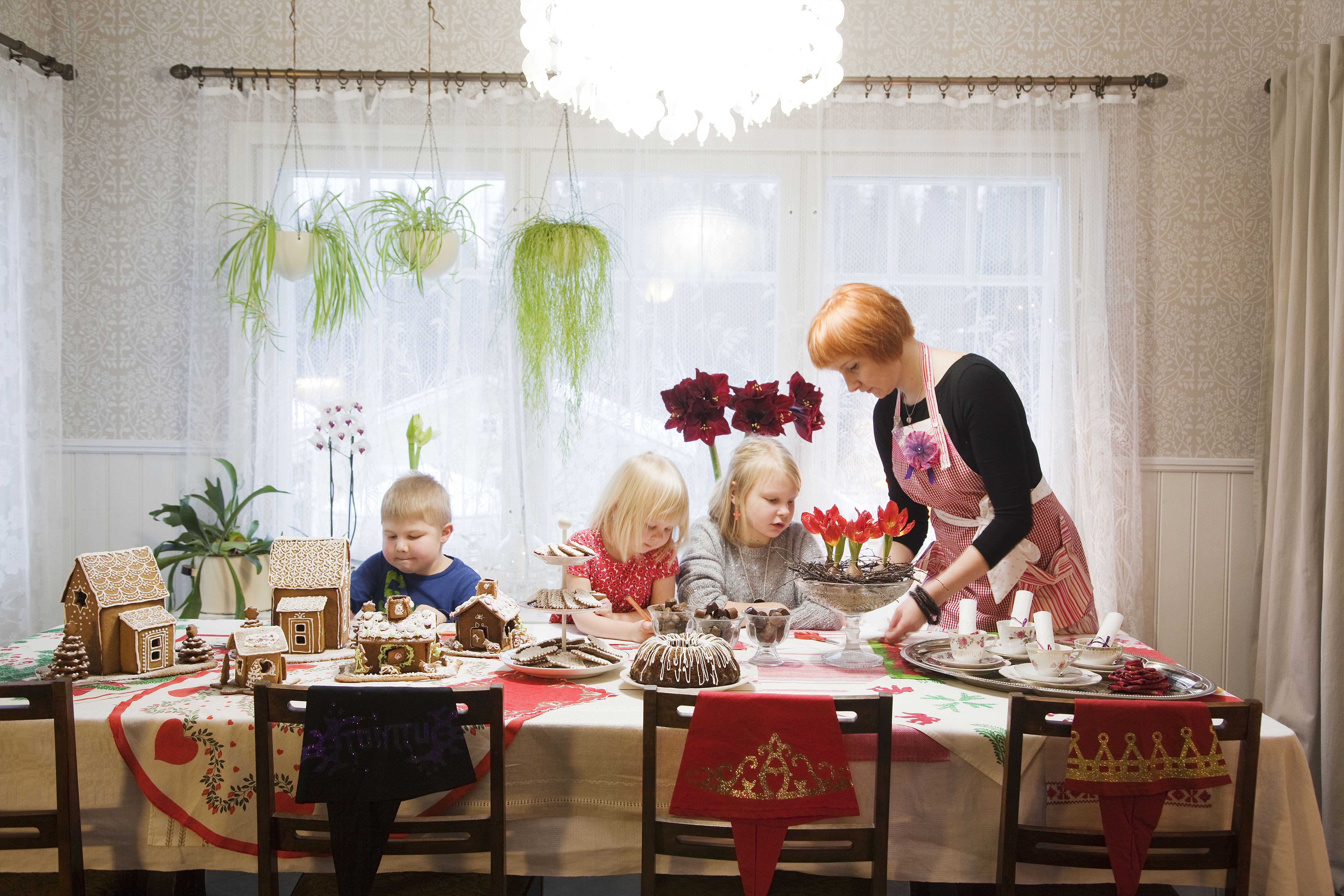 Suuren pöydän ääreen koko perhe – Eero, Siiri, Veera ja Katja – kokoontuvat piirtämään ja kokoamaan piparitaloja.