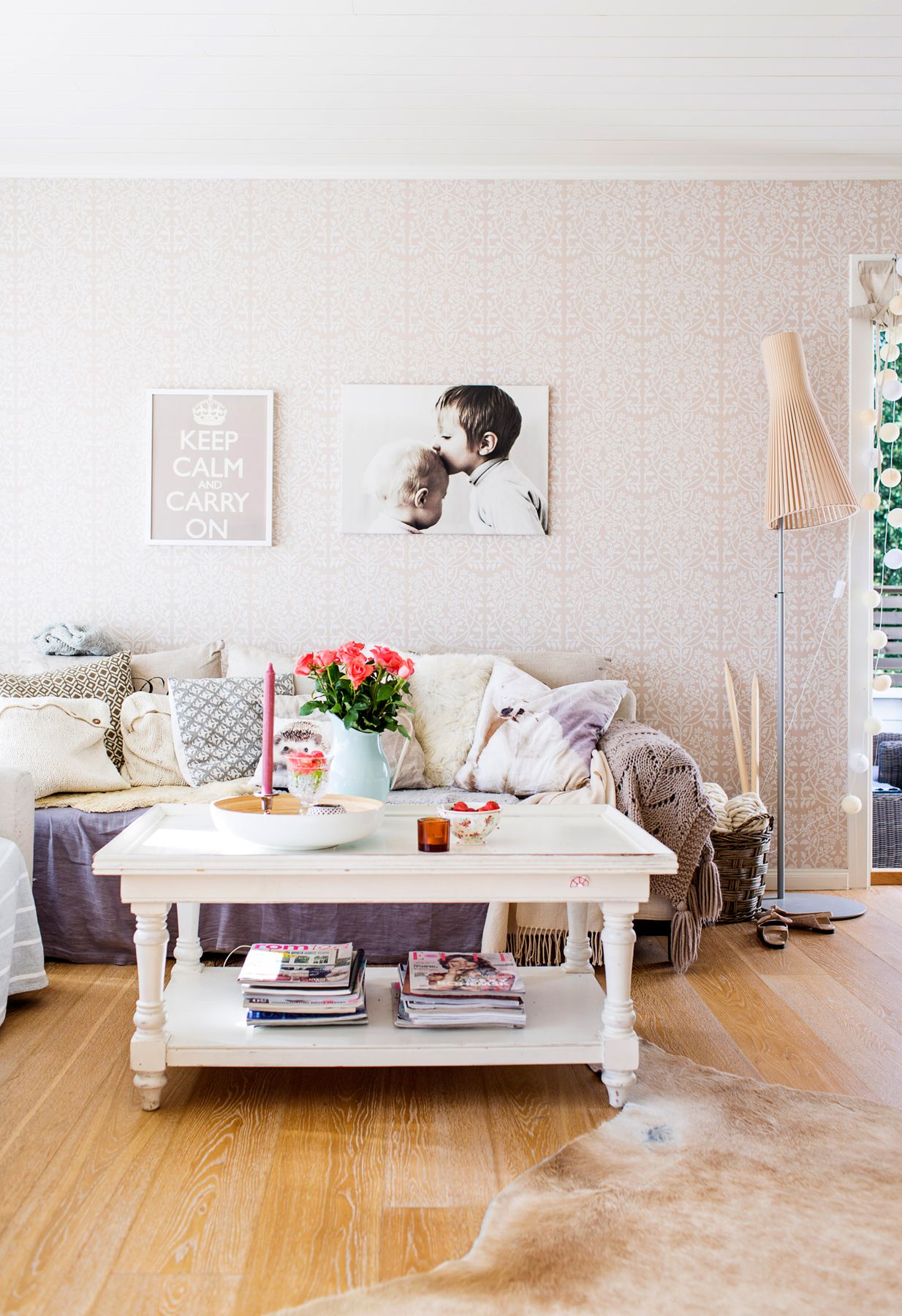 Lämpimästi puettu sohva kokoaa perheen syksyisin loikoilemaan. Johanna pitää sisustuksen maanläheisyydestä. Lämmin ja sopivan rosoinen sekoitus syntyy neuleista, taljoista, pellavasta ja vanhoista huonekaluista.