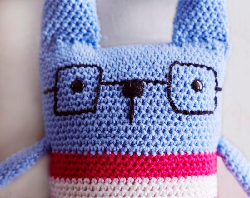 Kiinnitä pupulle turvasilmät, jotka eivät irtoa leikeissä. Nenä, suu ja silmälasit ovat tikki- ja laakapistoin kirjottuja.