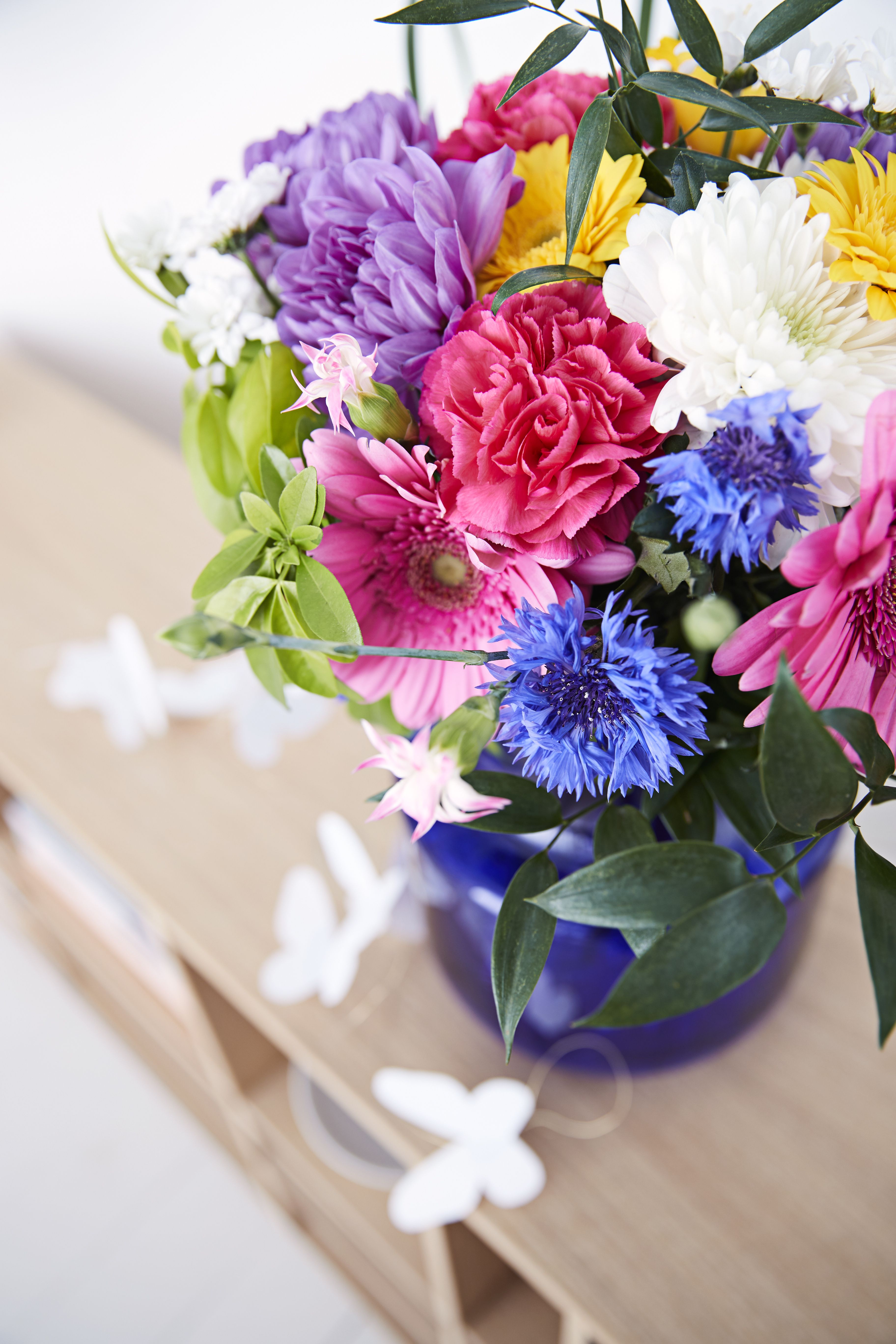 Laita somat perhoskiehkurat koristamaan juhlapöytää tai apupöytiä. Yksittäisen perhosen voi kiinnittää teipillä juomalasien reunaan tai pilliin. Jos juhlissasi on kattaus, kirjoita perhoseen nimi ja tee siitä paikkakortti. Menu-listakin näyttää viimeistellyltä, kun teippaat nurkkaan kolmiulotteisen perhosen.