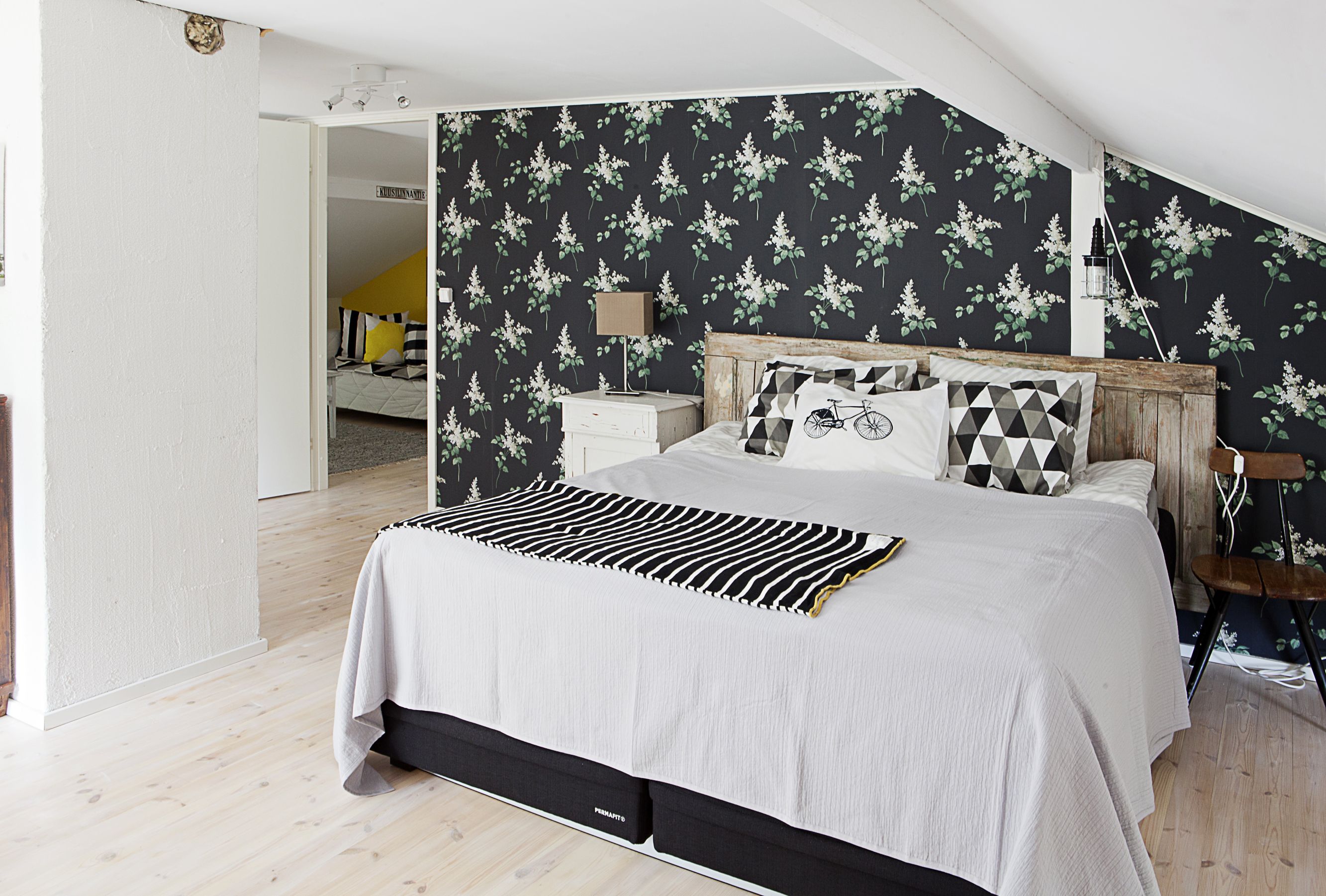 Makuuhuoneen tummapohjainen Sireeni-tapetti löytyi Boråstapeterin mallistosta. Vanha ovi sopii sängynpäädyksi.