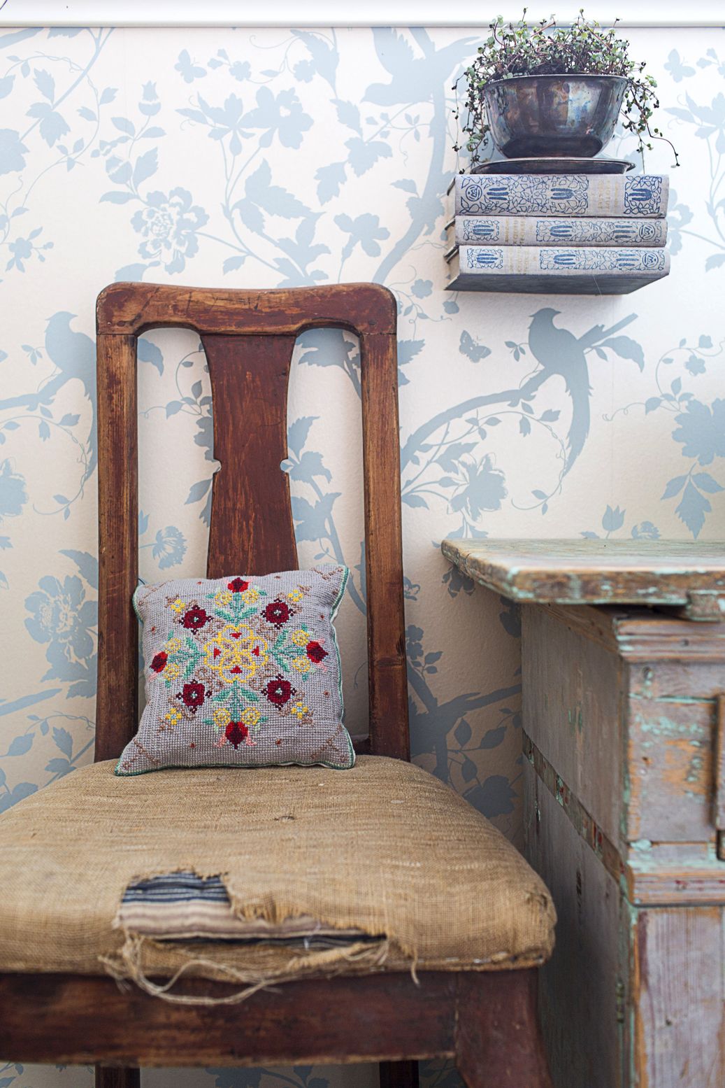 Tuolia on turha korjata, koska revennyt päällinen on vain sympaattinen. Kirjoista tehtyä hyllyä pitää seinällä alimman opuksen väliin liimattu kulmarauta.