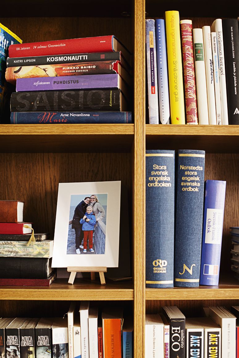 Kirjahyllyssä ovat perhekuva, romaanit ja sanakirjat.