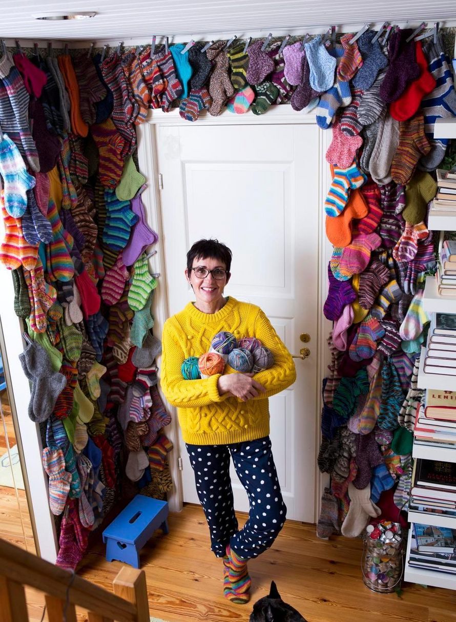 Ullamari kiinnittää valmiit sukat seinälle viritettyyn kanaverkkoon.