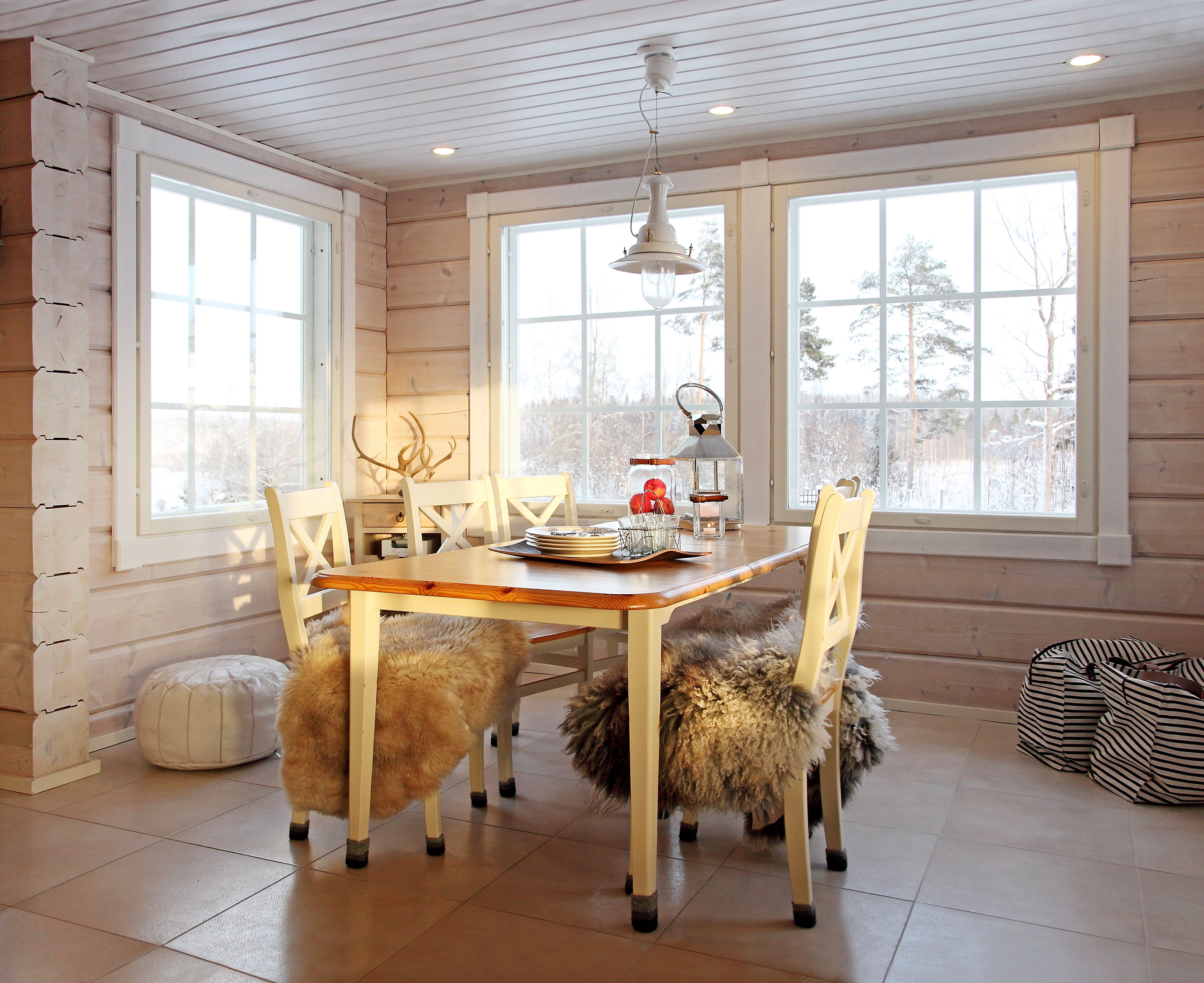 Tuolien jalat kirskuivat laattalattiaa vasten, joten Tarja virkkasi tuoleille ja pöydälle harmaat villasukat. "Emme halua erkkeriin tai muuallekaan ala­kertaan verhoja. On ihanaa, että luonto näkyy sisään.”