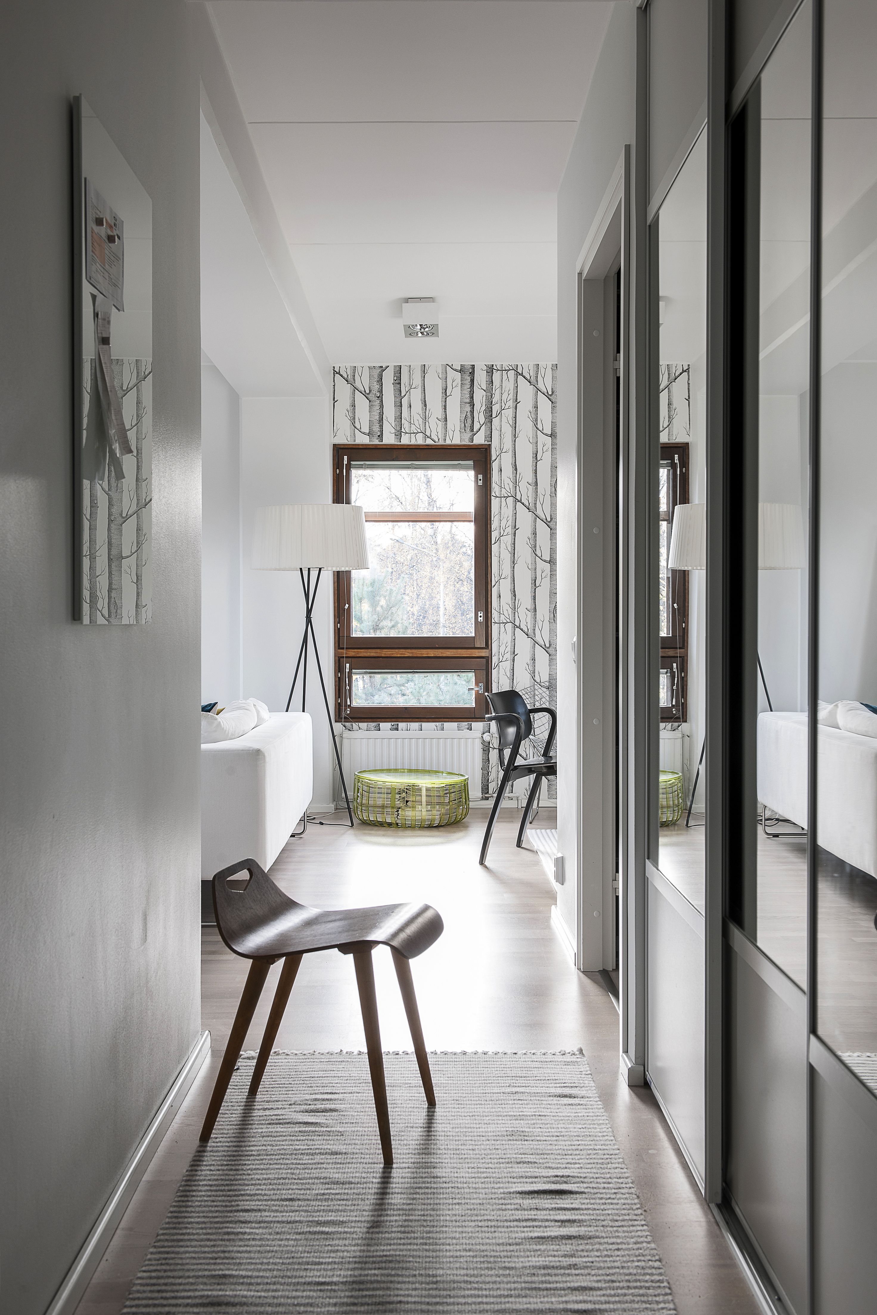 Kapeaan eteiseen mahtuvat liukuovien taakse kätketyt vaatteet, muistilaput kokoava magneettitaulu ja vanha, pieni jakkara, joka on hyvä apu lapsen pukemisessa. Matto on Tikaun.