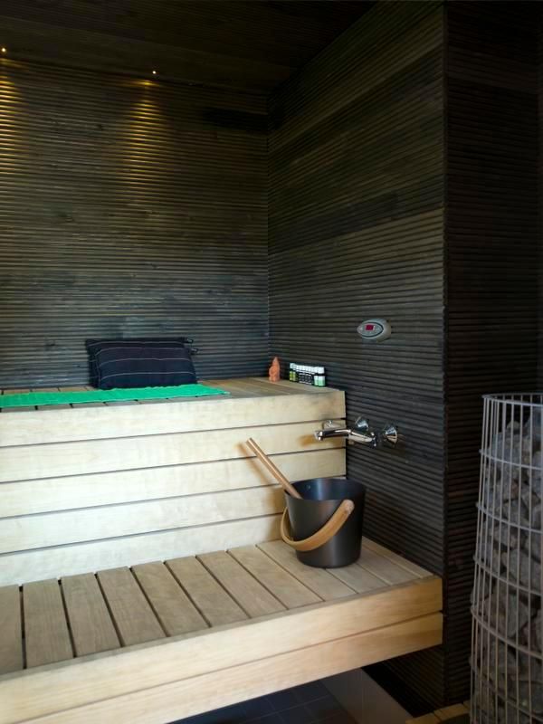 Tummasävyinen sauna lämpiää melkein joka päivä. Teemu nikkaroi lauteet haavasta. Myös yksityiskohdat on hiottu loppuun. Siksi saunan ovenkahva on maalattu vihreäksi.